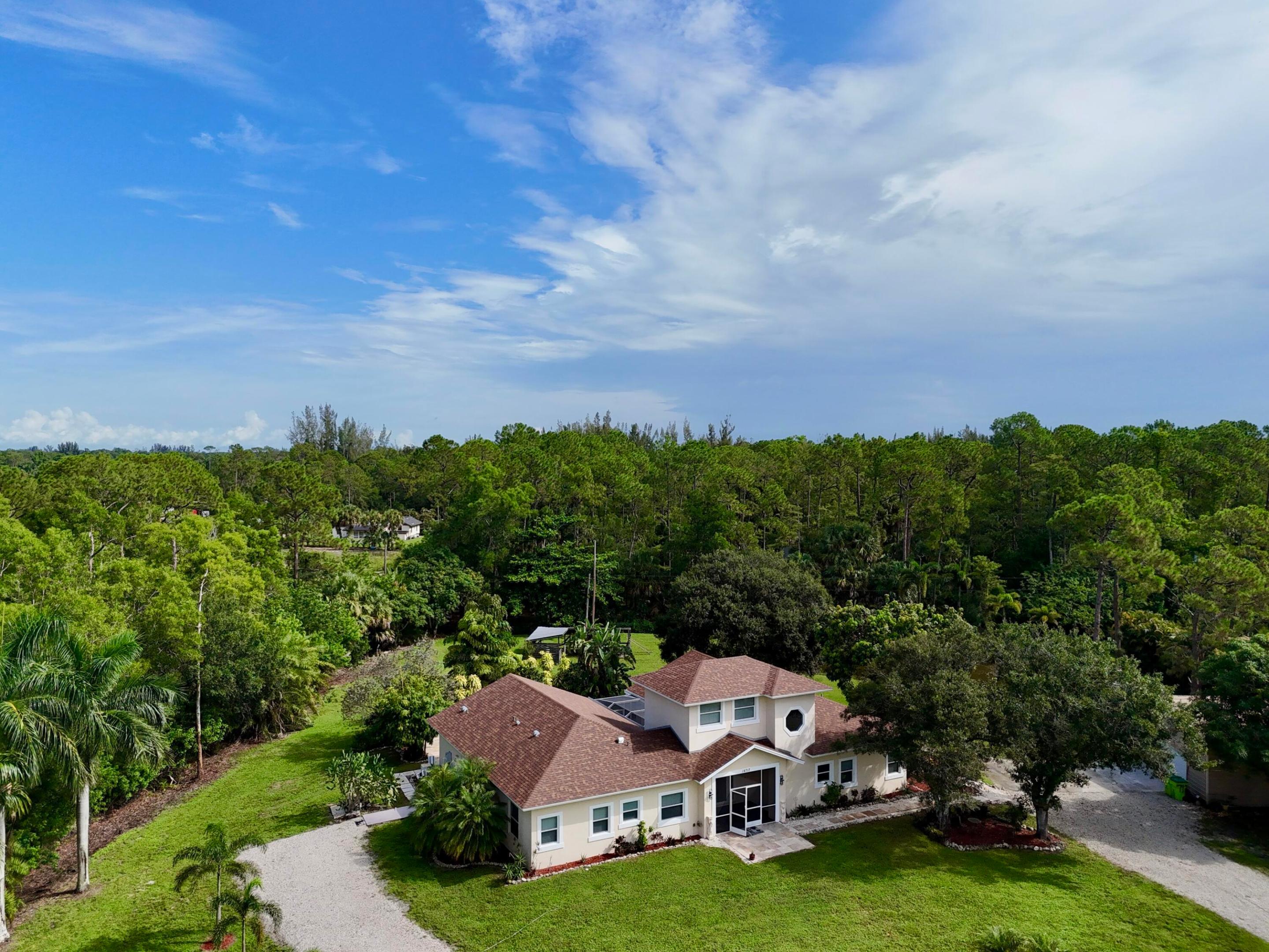 Situated on a private 1.84-acre gated lot, this spacious 4-bedroom + loft/optional 5th bedroom, 3.5-bath home offers the perfect blend of functionality, flexibility, and outdoor living. Inside, the home features an open and expansive layout with multiple living areas, a dedicated entertainment space, and a large kitchen that flows seamlessly into the main living area, ideal for both everyday living and hosting. The additional loft provides flexibility for a home office, guest space, or 5th bedroom. Step outside to a screened-in pool and patio overlooking the property's private pond and newly updated dock (2025), creating a peaceful and private setting. The property is equipped for a variety of lifestyles, featuring a large detached garage, multiple storage buildings, and three horse stalls offering space for equipment, hobbies, or recreational use. Recent upgrades include a new roof (2025), hurricane-impact windows and doors on the first floor (2025), two tankless gas water heaters (2025 & 2020), an updated HVAC system, and a water softener system. This is a rare opportunity to own a gated acreage property with usable land, modern upgrades, and versatile living space — all in one.