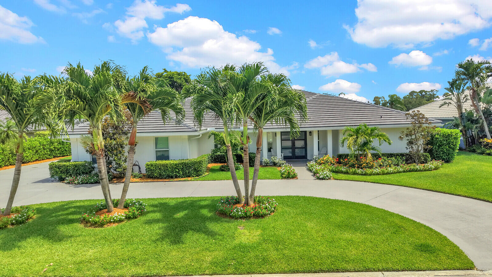 Welcome to this beautifully maintained golf course residence in the City of Atlantis, one of Palm Beach County's best-kept secrets. Perfectly positioned on the 8th hole of the Atlantis Country Club golf course, this exceptional pool home offers over 3,100 square feet of thoughtfully designed living space on a beautifully landscaped expansive lot, combining an outstanding floor plan, spacious rooms, and an impressive list of major improvements. Designed for both everyday living and effortless entertaining, the home features a highly desirable split floor plan with 3 bedrooms, 3 full bathrooms, a dedicated office/den, multiple living and gathering spaces, and a private guest wing with two bedrooms and two full baths. The oversized primary suite serves as a peaceful retreat with two walk-in closets and private access to the covered lanai and pool area. Step outside to your own private backyard oasis, where a screened pool, covered lanai, mature privacy hedges, lush landscaping, and a fully fenced yard create the perfect setting for relaxing or entertaining while enjoying tranquil golf course views. Exceptional curb appeal is complemented by extensive landscape enhancements, new exterior lighting, gutters, and fresh exterior paint. This home offers incredible peace of mind with an extensive list of capital improvements already completed, including a new 2024 tile roof, full impact windows and doors, an impact-rated garage door, two newer HVAC systems, all new ductwork and air grilles, blown-in attic insulation, newer water heater, and numerous exterior updates. The pool has been upgraded with a new pump and recently inspected to confirm it is fully operational and leak-free, allowing you to simply move in and enjoy. Additional highlights include a two-car garage plus a dedicated golf cart garage, making it easy to take advantage of Atlantis' golf cart-friendly streets and relaxed lifestyle. Located within the prestigious gated City of Atlantis, residents enjoy three manned guard-gated entrances, an independent police department, beautifully maintained tree-lined streets, and the rare benefit of no mandatory golf membership. Golf enthusiasts can enjoy both the public championship Atlantis Country Club and the private Lost City Golf Club, while everyone appreciates the community's convenient location just minutes from shopping, dining, beaches, major highways, Palm Beach International Airport, and JFK Medical Center. Move right in and enjoy the extensive updates already completed, while adding your own personal style over time to this exceptional golf course home in one of Palm Beach County's most desirable hidden gems.