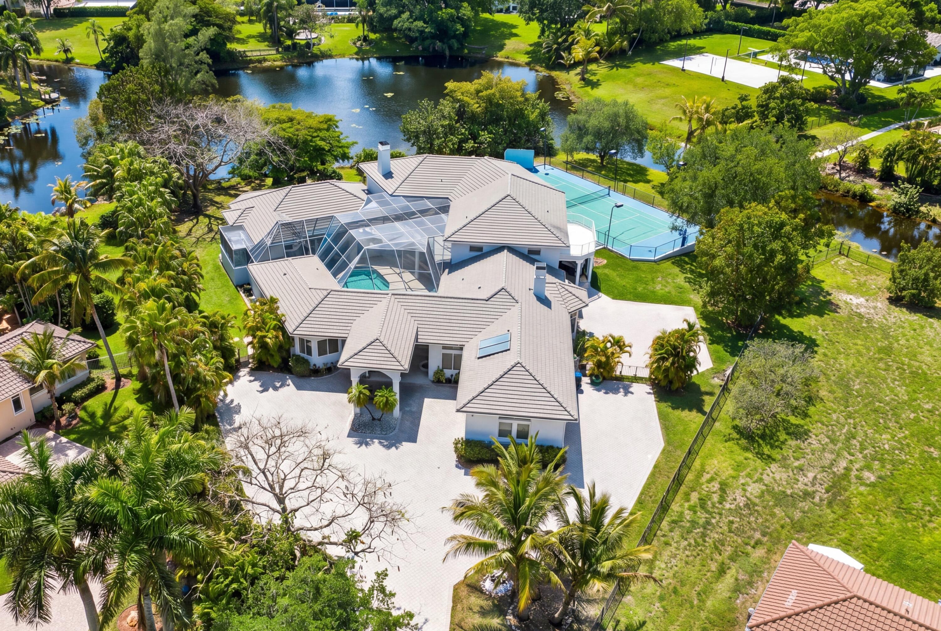 A rare estate of this scale and setting does not come around often. Privately positioned on nearly 1.8 acres at the end of a quiet cul-de-sac, this custom-built waterfront residence sits on an incredible pie-shaped lot surrounded by water and captures breathtaking lake views from one of the highest elevations in the community.  Offering over 8,000 sq ft under air, this extraordinary home features 10 bedrooms, 10.5 bathrooms, a library/office, an expansive game room, and so much more designed for unforgettable entertaining. Soaring vaulted ceilings, generous living spaces, and a thoughtful floor plan create a true estate feel throughout. The main level was built and designed with safety, comfort, and effortless entertaining in mind, featuring two spacious primary suites, a private library/office, TV room, two additional bedrooms and a chef's kitchen appointed with two sinks, two dishwashers, a wet bar, breakfast nook, and two oversized pantries. Each bedroom includes its own en-suite bathroom and walk-in closet, offering exceptional privacy and convenience for guests.   The second level offers two additional bedrooms and a large loft, creating the perfect flexible space for a lounge, media area, playroom, or additional retreat. Outside, the estate continues to impress with a resort-style pool, basketball court, and tennis court that can easily be converted to pickleball.  A 4-car garage, along with generous front and side parking, provides incredible space for vehicles and guests. Additional features include partial impact windows and doors, a newer roof installed in 2020, NO HOA, and a thoughtful design centered around safety, privacy, and peace of mind making this a truly rare opportunity to own a private waterfront estate with unmatched scale, setting, and lifestyle.
