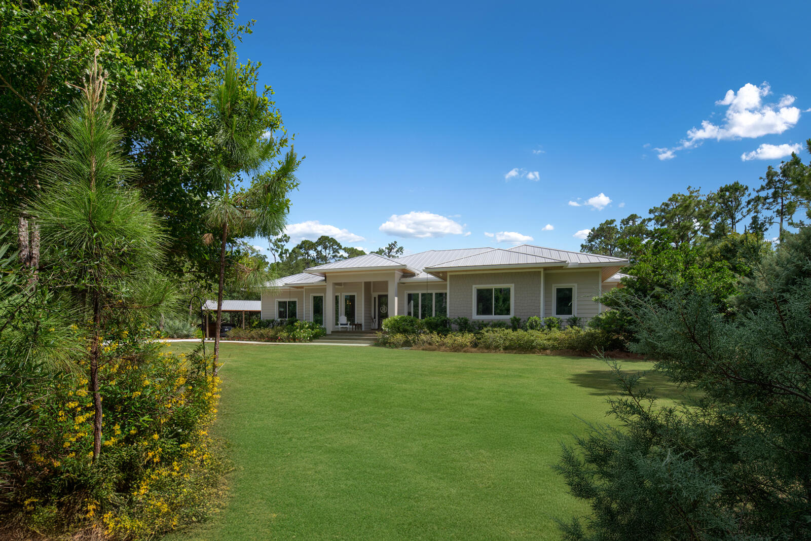 Welcome to 9010 Valley Oak Place, an exquisite meticulously maintained 5+ acre property in a prestigious private and sought after gated community. With lush landscaping, beautiful garden and fully fenced for privacy, this stunning estate is just minutes from I-95 and the Turnpike in the prime Jupiter location, offering easy access to shops, restaurants, and A-rated schools. Perfect for those seeking an equestrian paradise or a serene private retreat, this remarkable property combines tranquility with convenient proximity to everything you need.     The 2020 custom built farmhouse-style ranch features open floor-plan with high ceilings, four bedrooms, four bathrooms, a large open kitchen with an eat in dining area, all overlooking a large central great room.  There is a separate formal dining room, a formal living room, and a large mudroom/laundry room with built-in pantry shelving suitable for all your needs. The great room/family room has a ducted vented gas fireplace for those cozy feels and built-in wall units for added charm.   The gourmet kitchen is a chef's dream, equipped with Thermador appliances, including double ovens, a gas range, a built-in separate tower refrigerator and freezer, a separate under-counter ice maker, along with a two drawer under counter refrigerator and a warming drawer in the center island. Clever pull-out features in the lower cabinets maximize convenience. The butler's pantry features wine storage boxes above the upper cabinets. The expansive center island has a prep sink, and behind the cabinets, there is an area to discreetly store those necessary appliances you don't wish to see on your countertops.      Behind the poured solid concrete exterior walls are smooth finished interior walls is R11 insulation, complemented by spray foam insulation in the attic, allowing for energy efficiency and sound reduction. The home boasts solid core doors, 12' ceilings, and 10' bedrooms, creating an open and inviting atmosphere. Expansive 8' windows flood the space with natural light, while thoughtfully designed closet systems provide ample storage. Enjoy the elegance of 3' cedar tongue and groove soffits and a gas fire pit, which can be viewed from the center of the home.       Outdoor amenities include expertly landscaped grounds with approximately 1.5 acres of irrigated Bermuda grass, artificial turf, a rose garden, and a heavily treed, secluded environment that provides a private seclude atmosphere. Practical features such as an entire home reverse osmosis system, a whole-house generator, and two 4" deep wells with submersible pumps ensure seamless living. In addition to the gas fire pit, there are two wood-burning fire pits on the property.       Electrical service is robust with 400 amps, including a 30-amp Tesla charger. For those with recreational vehicles, this property offers two 50-amp RV hookups. The expansive 45' by 72' detached garage, with a block stem wall foundation and standing seam metal roof, provides ample space for vehicles and storage, while the 48' by 20' pole barn adds even more functionality. There are additional pole barns and structures for everyday conveniences. The property is secured with a no-climb horse fence, outdoor living spaces, an inner yard perimeter electric dog fence, and lightning protection in the stately pines that flank the view in the backyard.       This property is truly a unique find, blending luxury and practicality in a peaceful setting. More features to follow!