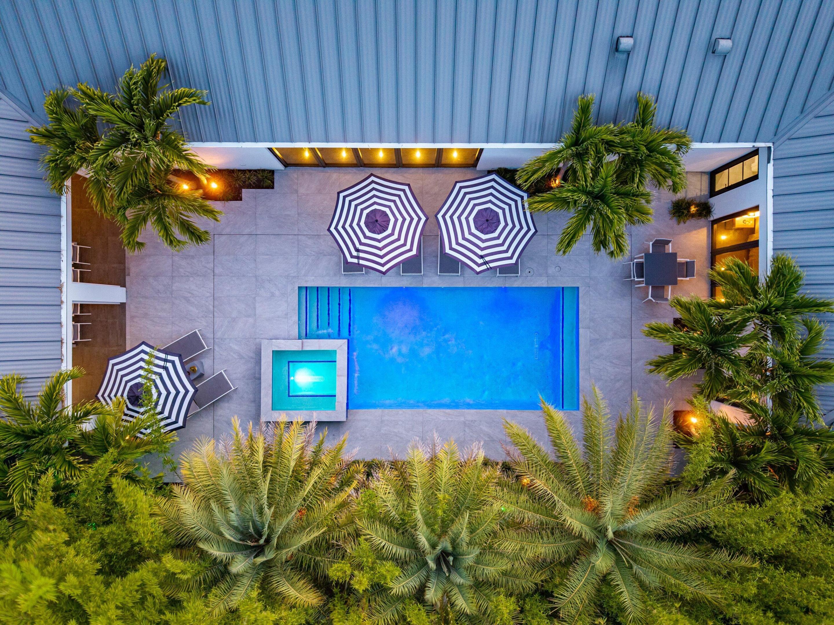 Tucked into the coveted Del Ida neighborhood on a lush large lot, this single-story modern residence is a world unto itself — part architectural statement, part private sanctuary. Walls of glass dissolve the boundary between indoors and out, while soaring ceilings, sculptural tile accent walls, crisp white finishes, and bespoke detailing compose an atmosphere that is sleek, considered, and unmistakably custom. Tropical modern design at its most refined. Set across 3,235± square feet under air, the residence offers 3 bedrooms, 3 full baths, and 2 half baths — a layout conceived for effortless daily living and seamless entertaining at any scale. At the heart of the home, a European-inspired chef's kitchen commands attention with custom cabinetry, premium appliances, dual built-in  Bosch refrigerators, and a waterfall island with seating. An adjacent full bar with wine storage makes hosting feel instinctive. Beyond the glass, a lush tropical backyard unfolds: a fully automated saltwater pool and spa, screened patio with automated roll-down screens, and layered landscaping engineered for complete seclusion. The property is as private as it is polished. The home's infrastructure matches its aesthetics — whole-house generator, Sonos sound system, Lutron lighting and electric shades, CAT6 wiring throughout, and a smart-home platform that puts full control at your fingertips. An oversized garage, air-conditioned attic storage, and dual driveways accommodating 10 to 12 vehicles round out a property that anticipates every need. Moments from Atlantic Avenue, the boutiques and dining of downtown Delray Beach, and the ocean, 1275 N Swinton Avenue is a rare convergence of bold architecture, resort-caliber amenities, and genuine privacy — in one of South Florida's most sought-after neighborhoods. Available seasonally at a higher price.