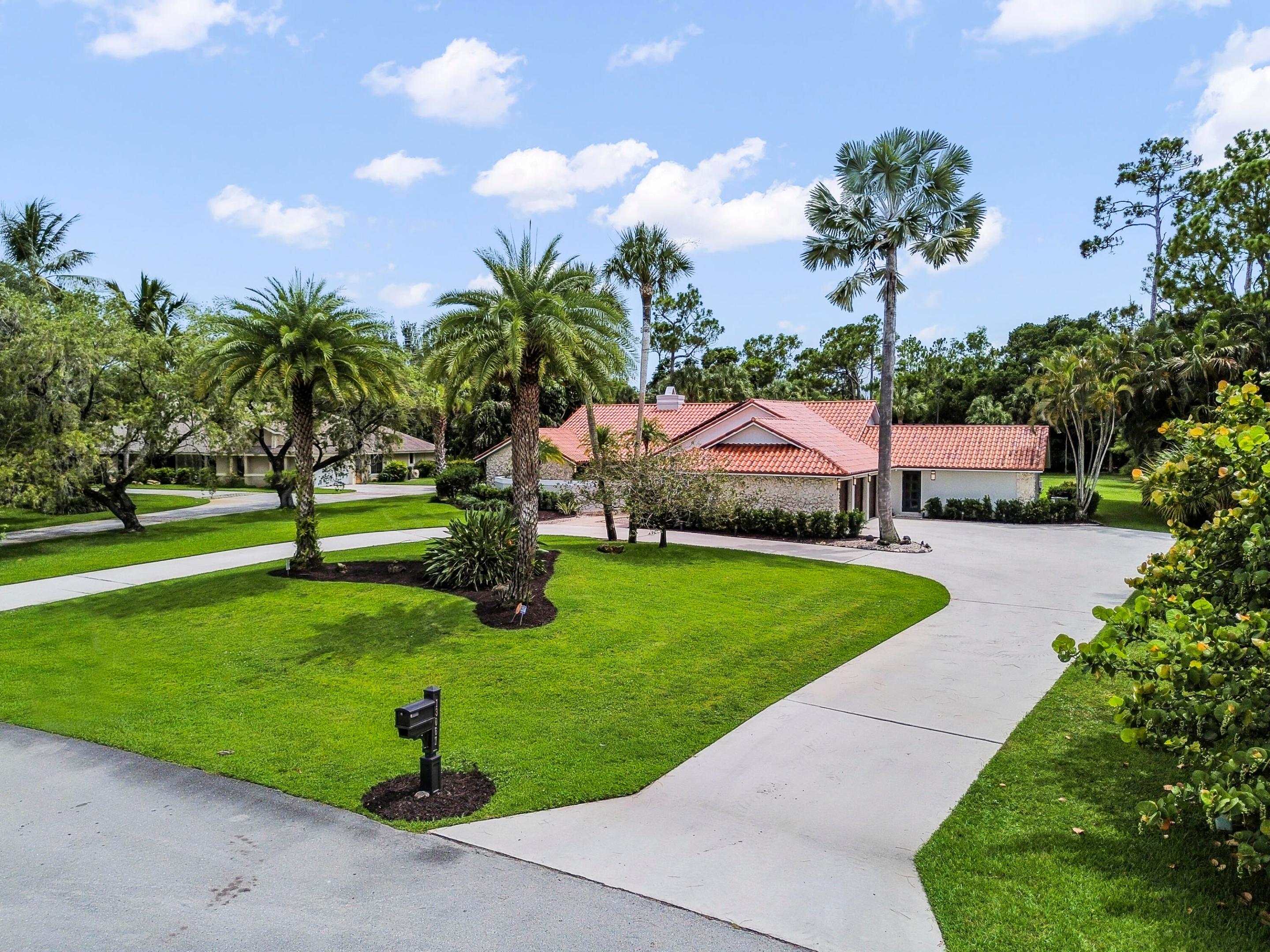 Welcome to 13067 Doubletree Circle, a beautifully 4 bedrooms and 4 bathrooms Wellington retreat where modern luxury meets relaxed Florida living. From the lush tropical landscaping and circular drive to the bright, open interior, this home makes an unforgettable first impression. Inside, soaring ceilings, large windows and doors, elegant flooring, and a striking statement fireplace create a polished yet comfortable feel throughout the main living spaces. The kitchen is a true centerpiece, thoughtfully designed with upgraded cabinetry, sleek finishes, a custom Sub-Zero refrigerator/freezer, wine tower, and upgraded appliances. The home also offers beautifully remodeled bathrooms, including a luxurious primary bath with a steam shower, body jets, and soaking tub. Additional interior highlights include updated light fixtures and ceiling fans, Hunter Douglas window treatments, an oak library with a full cedar closet, and a spacious upgraded laundry/storage area with pullouts for added convenience.  Outdoors, the private screened pool and patio area creates a peaceful setting for entertaining, relaxing, and enjoying the surrounding greenery. Major updates include a hurricane-rated roof with skylights, impact glass windows and doors, hurricane-rated garage doors, solar panels tied into FPL, a propane tank, refreshed landscaping, and a complete exterior repaint. This Wellington home delivers comfort, efficiency, and refined design in one impressive package.