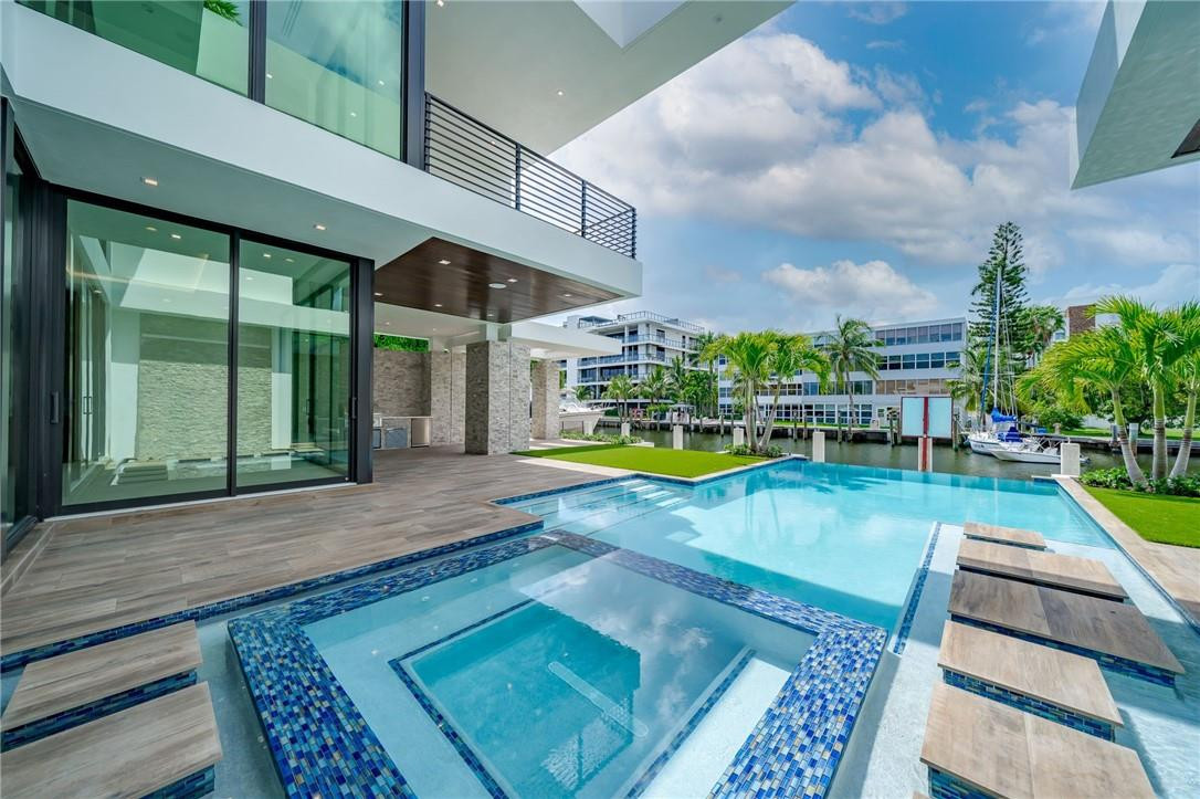 BRAND NEW CONSTRUCTION almost complete in Las Olas Isles!! Modern construction & design by Paterson Project Management beautifully creates today's buyer's preference of glass & white walls contrasted with dark wood floors & stone detailing. The glass throughout is floor to ceiling including the main living area which features a two-story glass window offering a lovely city & water view from the 2nd floor catwalk. The house contains SIX bedrooms (3 Master/VIP suites w/large private balconies/patio)/7.1 baths + office; a superb layout that's manageable but generous. New concrete dock with 90FT of waterfront allows up to a 70FT boat.  Ultimate outdoor living with 45FT POOL, 10x10 waterfall spa, & covered summer kitchen. 3 car garage. No fixed bridges; just minutes to Intracoastal & Inlet.