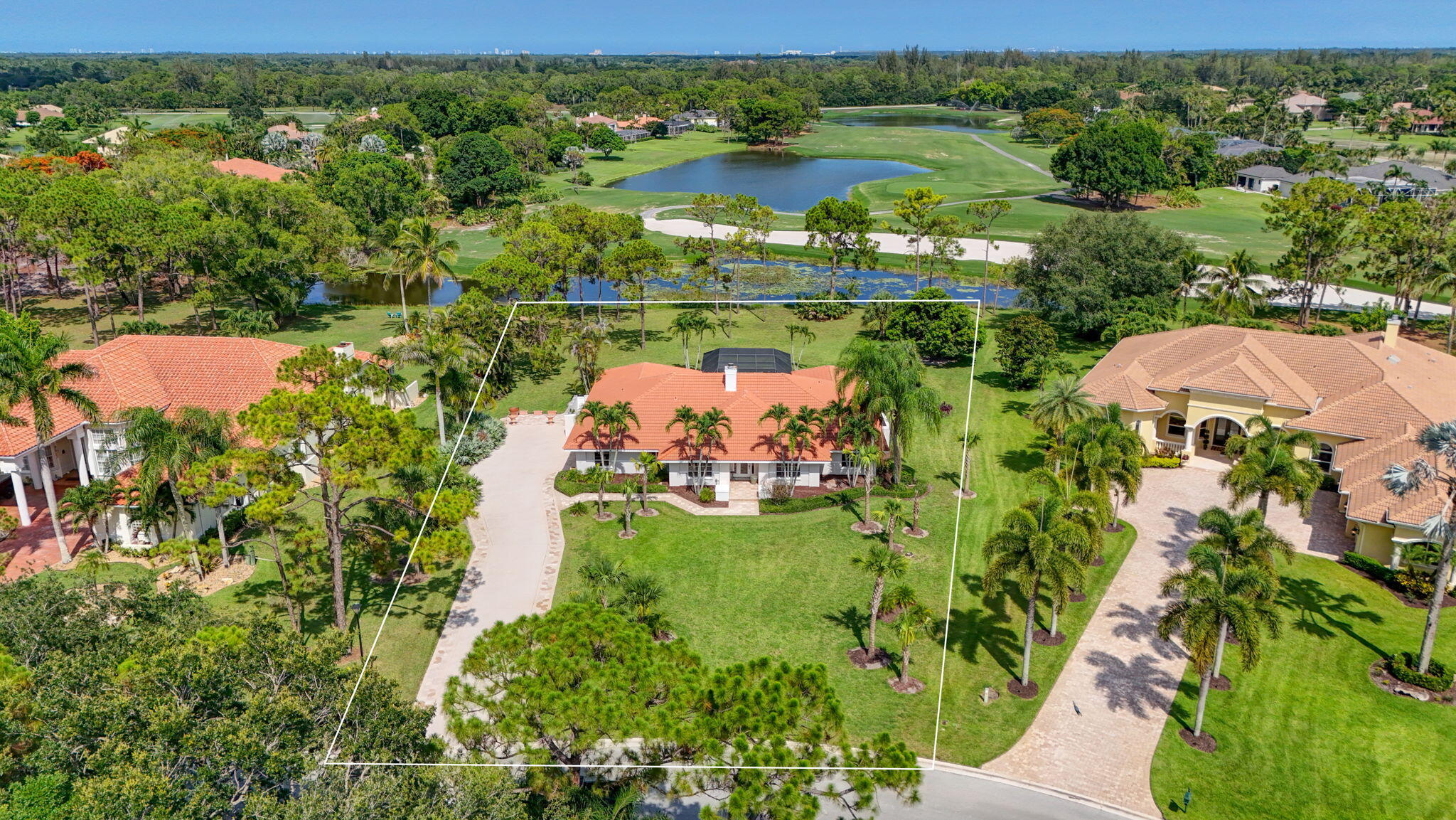 Nestled on over an acre of land in the gated, tranquil golf course community of Bay Hill Estates, this custom-built, waterfront residence offers a rare combination of privacy, natural beauty, and breathtaking views. Surrounded by lush South Florida landscapes, the property overlooks sweeping golf course vistas, sparkling waterfront scenery, and abundant wildlife, creating a peaceful retreat that feels worlds away from the everyday. Designed for both comfortable family living and memorable entertaining, this single-level, 3-bedroom, 2.5-bath home features spacious living areas filled with natural light and endless views of the surrounding beauty.  The centerpiece of this warm and inviting residence is the dramatic stone fireplace, creating a stunning focal point and a welcoming gathering place for family and friends. Complementing the living space is a custom-built bar in the family room, making entertaining effortless and enjoyable. The outdoor pool and spa are located in a very large screened-in area overlooking the massive property. Whether enjoying your morning coffee while watching the sunrise over the water or hosting guests for an evening by the fire, every space has been thoughtfully designed to embrace comfort, connection, and the serenity of its surroundings.  Privacy abounds throughout the expansive homesite, offering room to relax, unwind, and embrace the outdoor lifestyle that makes South Florida so desirable. With over an acre of land, ample parking for family and guests, and picturesque surroundings, this property presents a unique opportunity to enjoy estate-style living in one of Palm Beach County's most sought-after golf course communities. The custom design, exceptional setting, and peaceful atmosphere make this home a true retreat. Experience the beauty, tranquility, and timeless appeal of Bay Hill Estates right in the heart of Palm Beach County.