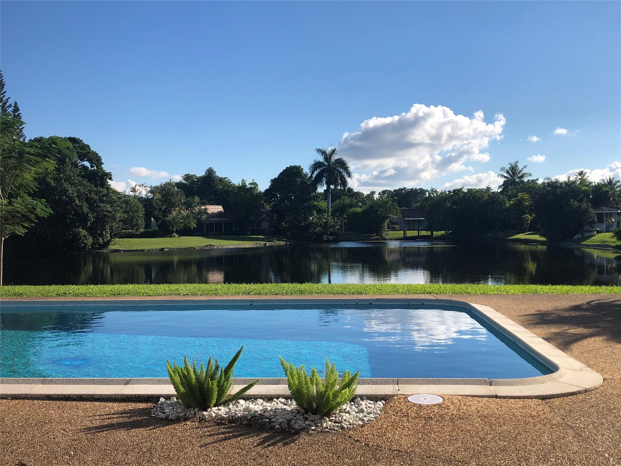 WAKE UP TO A SPECTACULAR VIEW OF THE LAKE IN A 4 BEDROOM, 3 BATH SINGLE STORY HOME LOCATED IN JACARANDA COUNTRY CLUB, A GOLFER'S PARADISE.  NO MANDATORY GOLF MEMBERSHIP.  ANNUAL HOA IS UNDER $500/YEAR.  OPEN FLOOR PLAN, 2 CAR GARAGE WITH A 2021 INSTALLED HURRICANE RATED DOOR, LARGE CIRCULAR DRIVEWAY, GATED BACKYARD WITH A FABULOUS POOL (DIAMOND BRITE AND TILED IN 2021) TWO 5 TON AC UNITS (REPLACED IN 2021) NEW KITCHEN CABINETS AND COUNTERS (JAN 2024), TWO WATER HEATERS REPLACED 2021.  HURRICANE RATED 10' SLIDING DOORS AND KITCHEN WINDOWS OVERLOOKING THE LAKE (2021).  WATERPROOF VINYL THROUGHOUT (INSTALLED IN 2021-2023)