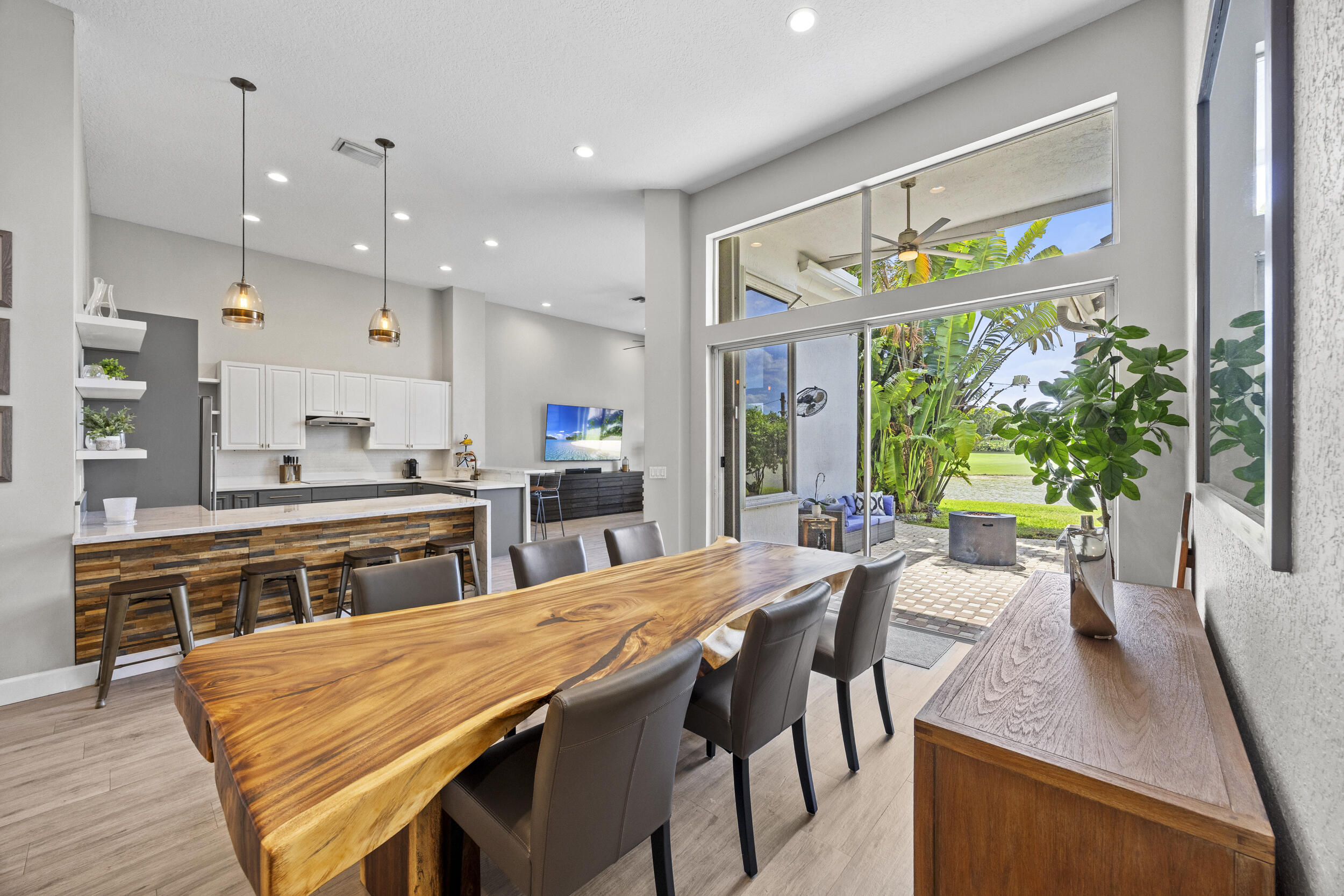 Experience luxury living in this stunningly renovated one-story home with 3 bedrooms, a private office, and 2.5 baths, perfectly positioned for sweeping lake and golf course views with breathtaking sunsets. Soaring ceilings and sleek wood-look porcelain tile create an airy, upscale feel. The showstopping kitchen features 42" white and gray cabinetry, quartz and marble waterfall countertops, stainless appliances, and a warm wood accent wall. French doors open to a private office, while spa-like bathrooms elevate daily living. The spacious primary suite offers custom closets and a true retreat feel. Enjoy peaceful evenings on the patio, where tranquil lake and golf course views create the perfect backdrop for unforgettable sunsets.