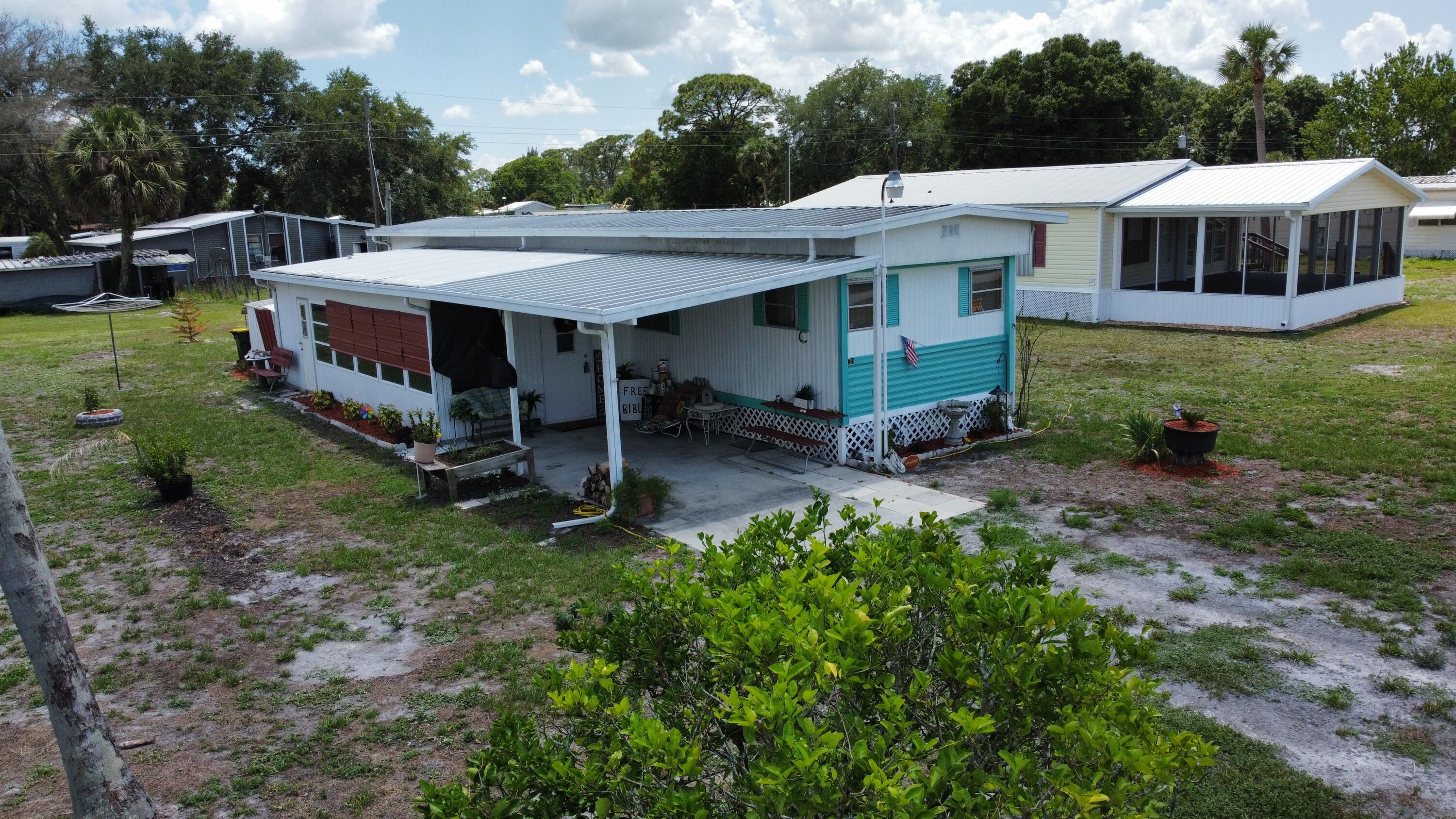 Kissimmee River Estates~Very cozy and delightful in every way, this well-maintained 2 Bed/2Bath mobile home offers comfort, functionality, and excellent value. The property features a durable metal roof, attractive landscaping, spacious carport, and ample parking space for multiple vehicles. Enjoy peace of mind with window awnings for added storm protection, updated electrical system with inspections passed, and a well-maintained A/C and water heater. Inside, you will find ceiling fans throughout, new carpet in both bedrooms, a convenient laundry room complete with washer and dryer, and a functional kitchen featuring a gas range. One of the highlights of this home is the very spacious screened room, perfect for relaxing or entertaining, complete with an additional bathroom and two side  entrance doors for added convenience. The property also includes two storage sheds, offering plenty of extra storage space. A charming and comfortable home ready for its new owners to enjoy!