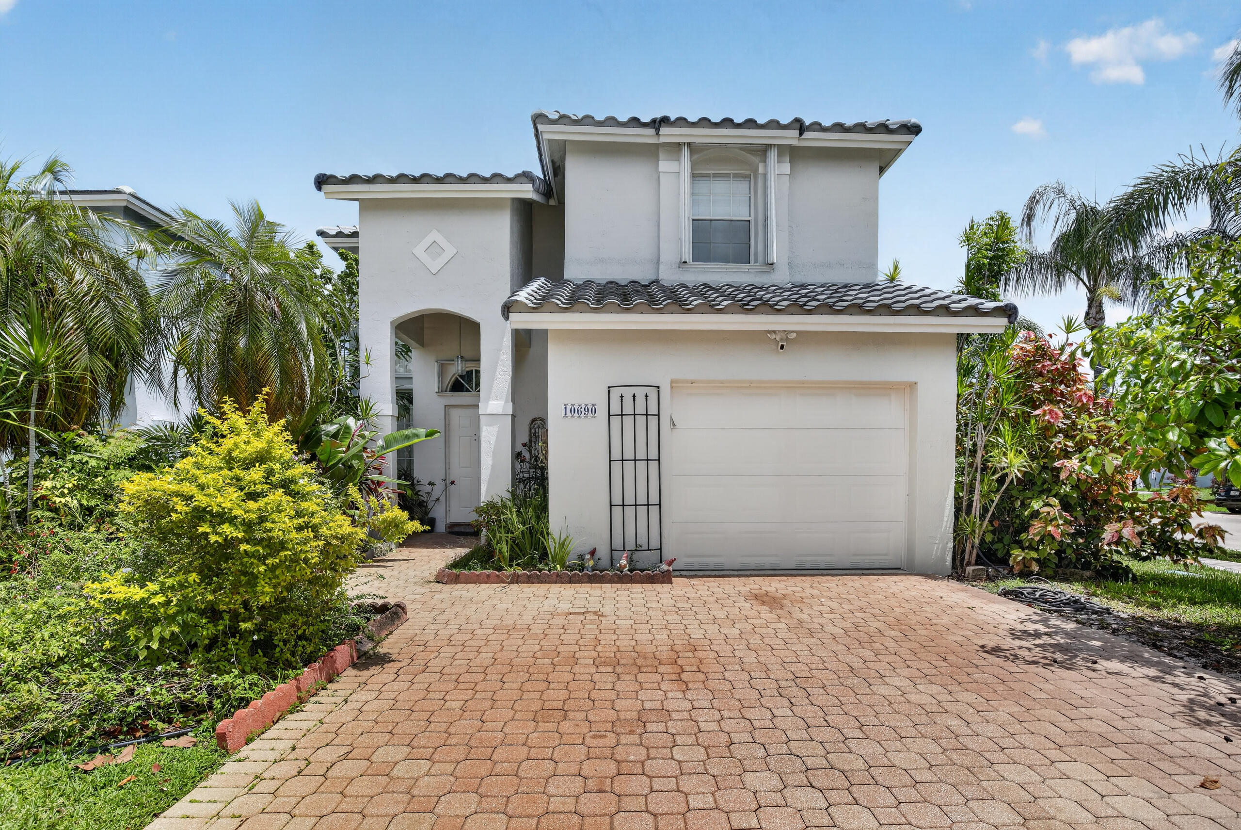 RARE CORNER LOT OPPORTUNITY IN PEMBROKE POINTE - THE PORTRAITS SUBDIVISION Welcome home to the only available property in this highly desirable, quiet, and established Pembroke Pines neighborhood! Situated on a premium corner lot, this beautifully designed 3-bedroom, 2.5-bathroom concrete block (CBS) construction home perfectly blends peace of mind, modern upgrades, and tropical outdoor living. UNMATCHED PIECE OF MIND & STRUCTURAL INTEGRITY Brand New Roof (2025): Newly installed double-waterproofed tile roof system with a full transferable warranty. Full Storm Protection: Equipped with easy-to-use accordion shutters and a hurricane-rated garage door. Fresh Exterior Paint (2025): Excellent curb appeal with newly updated exterior paint.  Mechanical & Appliances (2020): High-efficiency A/C system with all kitchen appliances fully updated. TROPICAL BACKYARD OASIS Step outside to a private backyard retreat enclosed by a privacy fence and manicured hedges. The partially covered brick paver patio is an entertainer's dream, framed by lush tropical landscaping and mature, producing fruit trees featuring: Mango, Avocado, and Banana trees. SPACIOUS & FUNCTIONAL FAMILY LAYOUT Downstairs Living: Designed for effortless flow with low-maintenance, beautiful tile flooring. Features a combined formal living and dining area, a separate cozy family room, a bright breakfast area, a convenient half-bath, and a dedicated laundry room. Kitchen Features: sleek granite countertops, premium LG Stainless Steel Smart Appliances, and a walk-in pantry. Upstairs Retreats: Plush, neutral carpeting carries you through three large bedrooms. The expansive master suite features a walk-in closet plus two custom wardrobes. Its en-suite bathroom includes double sinks, a massive soaker tub, and a separate walk-in shower. PARKING GALORE & UNBEATABLE HOA VALUE Parking is never an issue here. The oversized driveway comfortably accommodates 4 cars, plus a 1-car attached garage and additional street parking right on the side of the home. Best of all, enjoy a remarkably low HOA fee of just $180/month that packs unmatched financial value and maintenance protection: Comcast Cable TV included. Sparkling Community Pool access. Common Area Maintenance covering common grounds, swale trees, and palms. Zero-Cost Lawn Irrigation: The HOA completely maintains, repairs, and fixes your home's private lawn sprinklers. Even better, irrigation water is pulled directly from the lake—it is completely disconnected from city water, meaning it never hits your personal water bill. If a sprinkler head ever breaks, simply call the property management company and they handle it! This turn-key home is 100% ready to move in with a quick close available. Don't miss out on the neighborhood's best-kept secret!