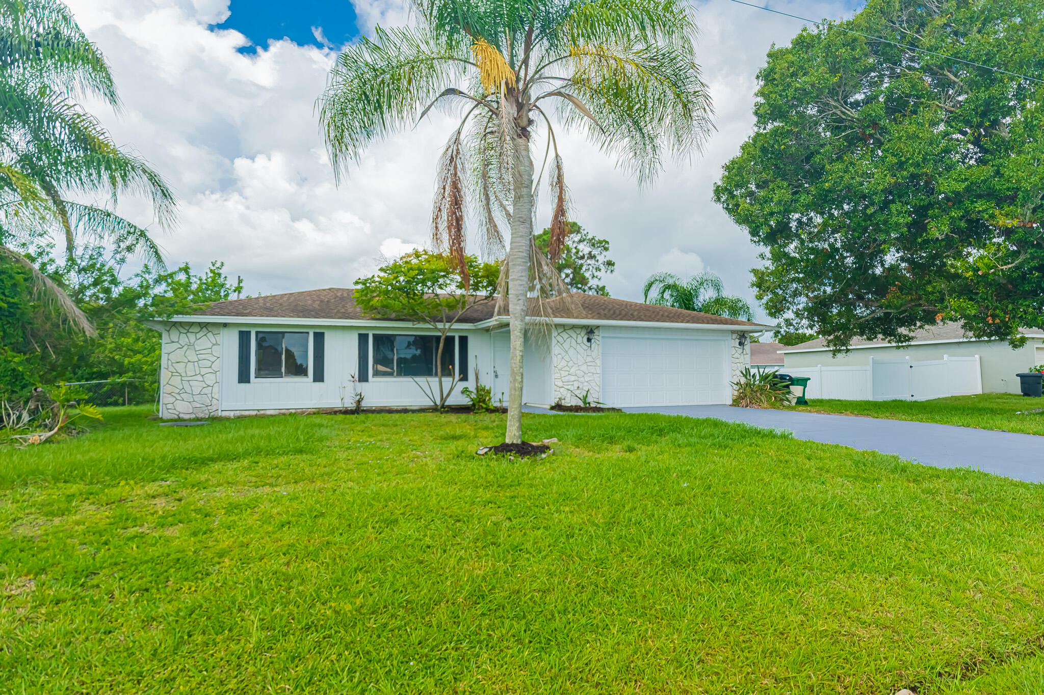Opportunity awaits! This freshly painted 2-bedroom, 2-bath home with a 2-car garage offers over 1,200 sq. ft. of living space and is ready for its next owner. Featuring brand-new flooring, an open floor plan, and a spacious oversized screened lanai overlooking an open backyard, this home provides the perfect foundation to make it your own. While it could benefit from remodeling and updates, it is move-in ready and priced for buyers looking to add their personal touch. Connected to city water and city sewer and conveniently located near shopping, dining, schools, parks, and major highways. Don't miss this chance—schedule your private showing today!