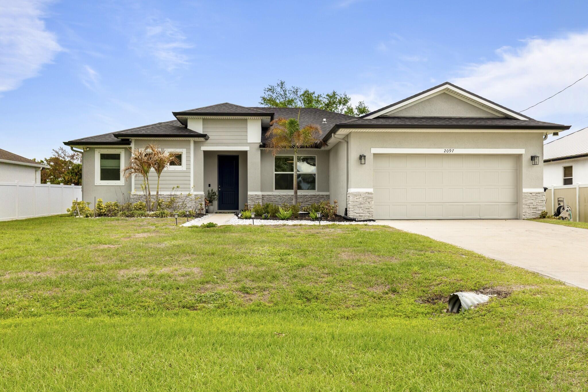 Spacious and beautifully upgraded 3-bedroom 2-bathroom 2-car garage + den/flex room Coastal Model, built in 2023, featuring tile flooring throughout and soaring 9-foot ceilings for an open, airy feel. This home is like new and has been meticulously maintained by the current owner, offering modern finishes and move-in ready comfort.  The kitchen is designed for both function and style with 42" cabinets offering abundant storage, granite countertops, white subway tile backsplash, a large island for entertaining, pantry, and Samsung stainless steel appliances including refrigerator, dishwasher, range, and microwave.  The owner's suite is a true retreat with a large, light-filled bathroom, window over the shower, private water closet, dual sinks, and his-and-hers spacious closets. Both bathrooms feature granite vanities, with tile extending on the walls in the secondary bath.  The home also offers ample closet space throughout and a convenient linen closet.   Step outside to enjoy a covered patio with extended paver porch area, complete with a lighted gazebo—perfect for relaxing, entertaining, or weekend BBQs. The property sits along the C24 canal, providing a peaceful and scenic backdrop.  Additional features include 8' interior and exterior doors, recessed lighting, tray ceilings, a 2-car garage with a oversize driveway that accommodates up to 4 vehicles, and rain gutters to protect the home and landscaping.  This like-new 2023 Coastal Model combines comfort, modern style, and careful maintenance—perfect for enjoying Florida living at its best!