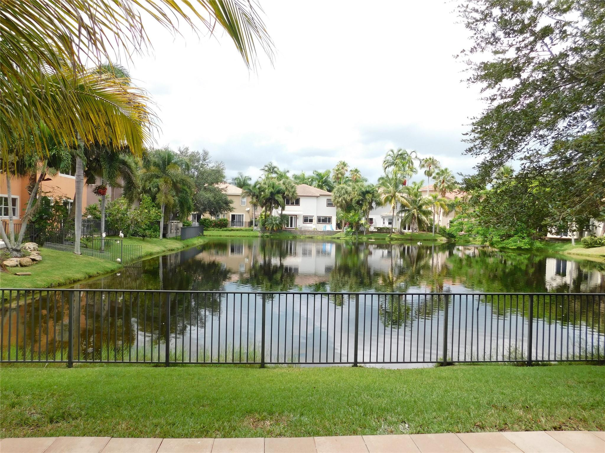 Beautiful, spacious, and impeccably maintained lakefront home located in a prestigious gated community in Plantation Acres. Experience the best of South Florida waterfront living in this exceptional four-bedroom, two-and-one-half-bath residence, featuring a dedicated first-floor office and stunning lake views. The home offers tile flooring throughout the main living areas, wood flooring upstairs, updated kitchen cabinetry, a new A/C unit, and an oversized two-car garage equipped with an EV charging outlet. The expansive primary suite includes a spacious bedroom and well-appointed bath, while the additional bedrooms provide generous living space. Ideally situated just a short walk from the renowned American Heritage School.  This home is located within one of South Florida's most desirable school districts. Residents also enjoy convenient access to Plantation's outstanding parks, recreational amenities, shopping, dining, and major transportation corridors. A rare opportunity to enjoy luxury lakefront living in one of Plantation's most sought-after communities.