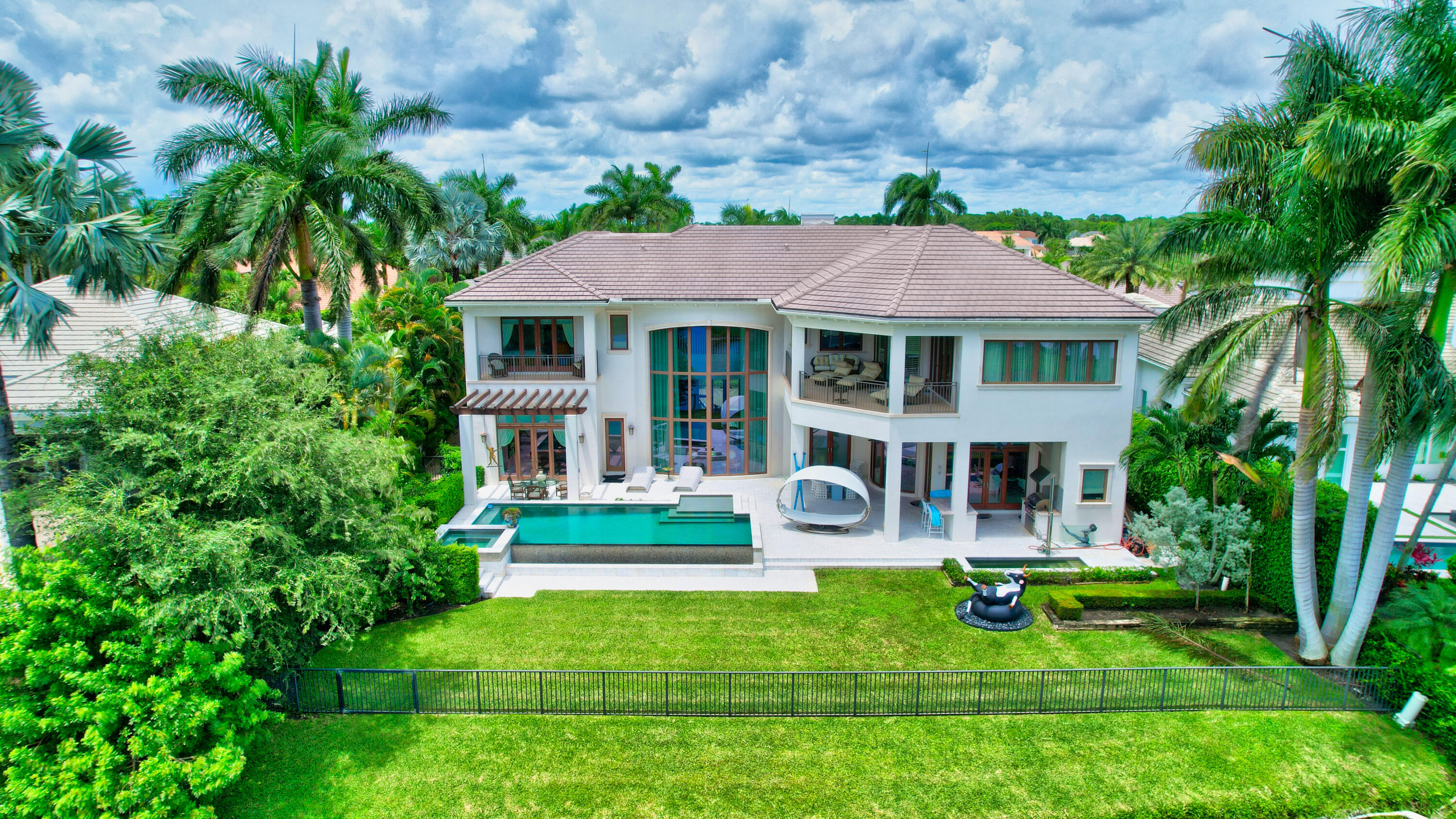 Custom smart home with 5 bedrooms, office, home theater, and one of the best lake & golf course views in St. Andrews CC! Built in 2012 with all impact windows, elevator, full-house generator, & more. The interior is open & bright, with custom designer details throughout. Gourmet chef's kitchen with double-wide Wolf gas cooktop & double ovens, 2 Sub-Zero refrigerators, 2 sinks, and large butler's pantry. Upstairs is an ultra-spacious master suite, with his & her baths, room-size custom closets, and a covered balcony. The 2nd floor also has 3 ensuite guest bedrooms and a game room. Outside is a resort-style pool w/spa, open and covered patio areas, and summer kitchen with built-in BBQ. Southern exposure and lake & golf course views. Note: Some furniture has been virtually restaged.