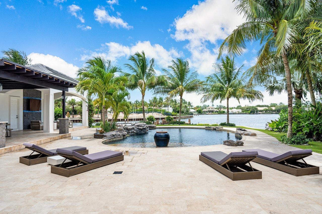 Recently Updated Transitional Waterfront Estate on over half an acre with 350' of water frontage situated in gated Captains Key Community. First and second floor master suites with an elevator outlooking scenic Little Lake Worth Lagoon. Soaring 12 foot and higher ceilings, smart technology and air purification system throughout. Chef's kitchen offers abundant counter space, two separate refrigerators, two dishwashers, two separate breakfast bars and a six burner gas cook top with griddle. Resort style backyard with East Exposure, offers saltwater smart pool and spa, patio area with an extensive covered loggia with two fire pits, waterfall wall and panoramic water views makes this house great for entertaining.