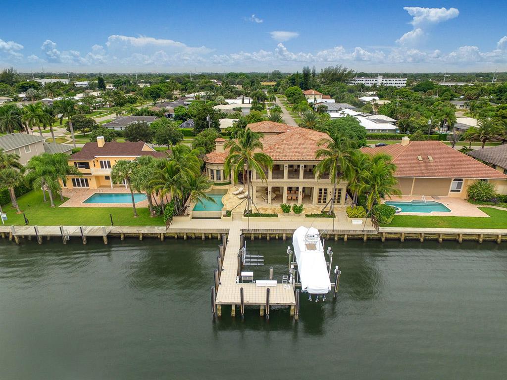 Waterfront Estate with 11,000 square feet and endless views of Lake Worth. Attention to every detail is evident wherever one looks. Enjoy wide water Intracoastal views. The first floor master bedroom has Brazilian Walnut flooring, a separate sitting room with a fireplace, separate his and hers bathroom suites, Italian Onyx wall ''lighted'' paneling, Onyx vanity tops, two story her walk-in closet and a fireproof vault room with security protection, poured concrete walls and ceiling and a built-in jewelry cabinet. The office has a Bamboo accent tray ceiling and Burlwood marble tops from India. The Gourmet kitchen has double dishwashers, a double wall oven, Dacor gas cooktop, custom cabinets and granite counter-tops. Other features include impact doors and windows, Turkish stone flooring, all new Bryant air-conditioners, new 100KW Kohler whole home generator, 1500+ bottle climate controlled wine room with slate flooring, large loggia containing a summer kitchen with a 42" pizza oven & built-in gas grill and climate controlled 4 car garage. The tiled concrete dock is equipped with 26,000lb and 5,000lb boat lifts, a filet table and two power pedestals.