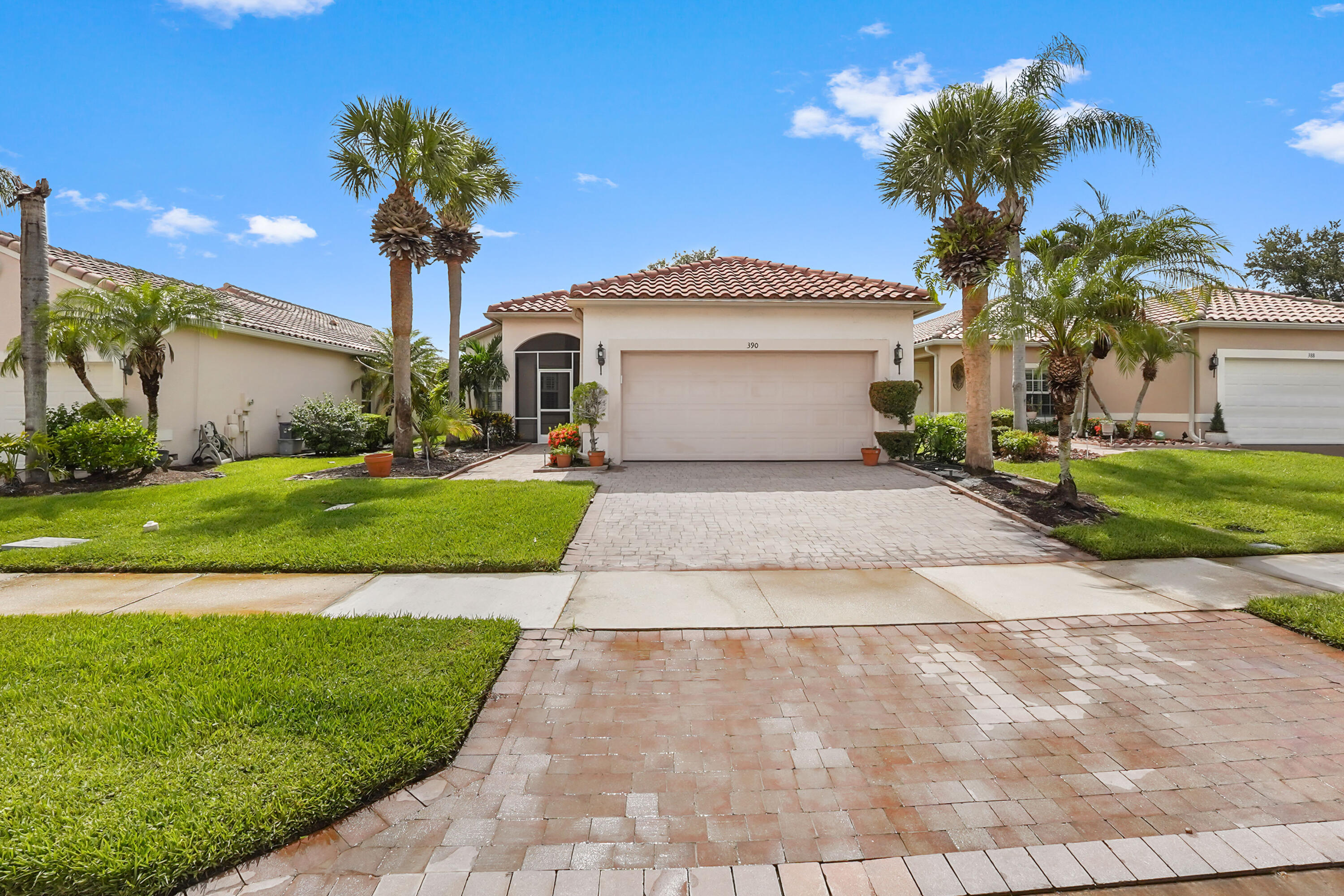 Welcome to this inviting lakefront retreat in the heart of a 55+ community in St. Lucie West, where manicured tropical landscaping and Mediterranean-inspired curb appeal create a memorable first impression. This thoughtfully designed single-story residence offers 2 bedrooms, 2 full bathrooms, 1,398 square feet of living space, and a 2-car garage. A paver driveway, covered entry, and graceful architectural details add warmth and character from the moment you arrive. Inside, bright and comfortable living spaces flow across tile flooring, complemented by ceiling fans, and attractive design details. The cheerful eat-in kitchen features stainless steel appliances and plenty of room for casual meals, while the spacious primary suite includes two walk-in closets and a private bathroom with dual vanities. The second bedroom and full bathroom provide a welcoming space for guests, a home office, or a relaxing hobby room.  The extended screened lanai is the true highlight, offering a peaceful setting to enjoy morning coffee, outdoor dining, or beautiful sunsets overlooking the lake. Whether entertaining friends or simply unwinding at the end of the day, this tranquil outdoor space captures the best of Florida living. With its comfortable layout, serene waterfront views, and convenient Port St. Lucie location, this charming home is ready to be enjoyed.