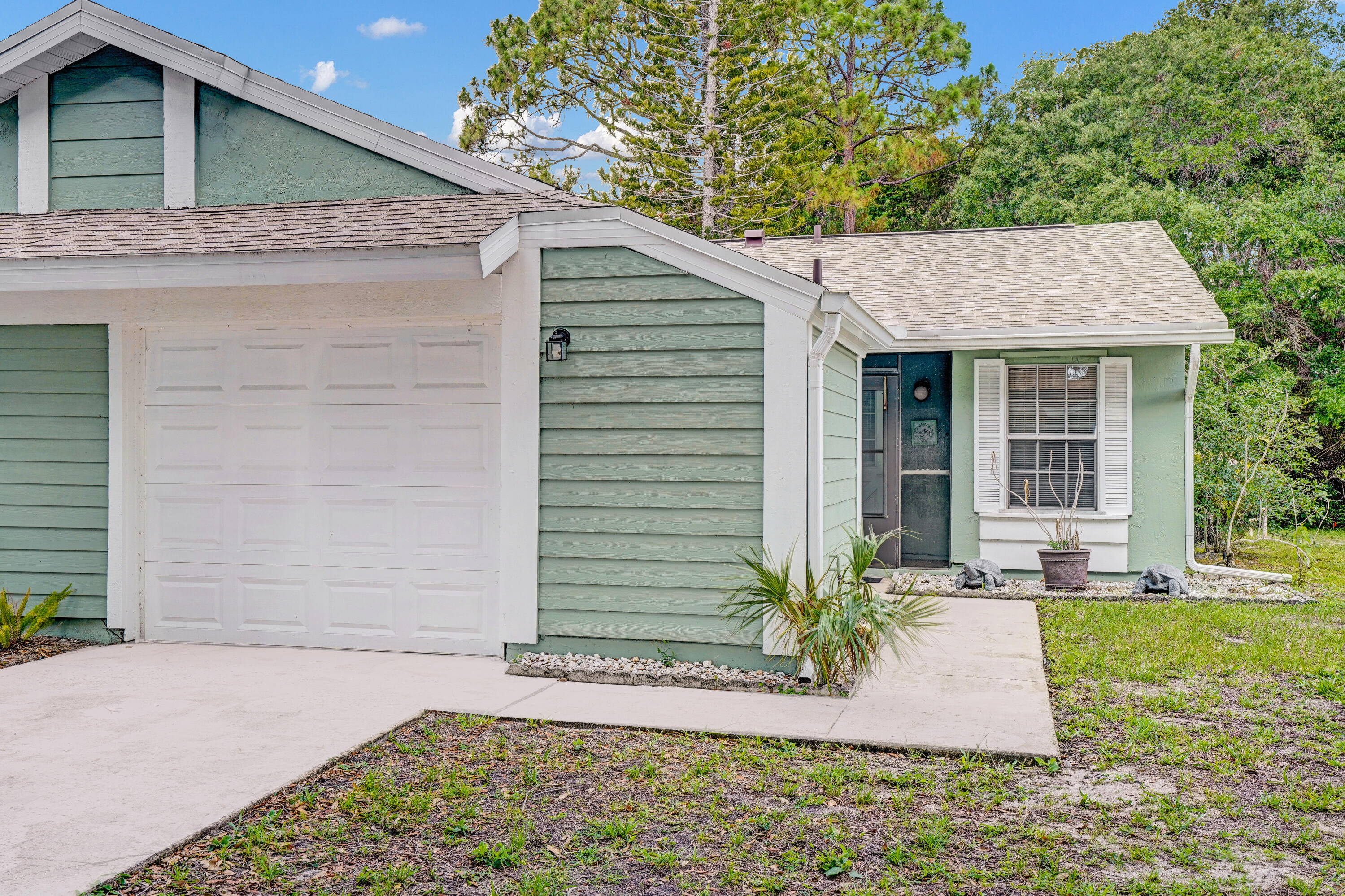This charming 2 bedroom/2 bath end unit villa is a unique find, with a new 2024 roof and vinyl plank flooring throughout the home. The kitchen has newer cabinets, granite countertops, and a snack bar island connecting it to the spacious open concept living area with plenty of room for entertaining. Past the living room, there is a flex room with large windows providing lots of natural light. It overlooks an expansive wooded preserve, creating a serene and peaceful atmosphere.  The community has a pool, tennis court, and clubhouse and is perfectly located close to everything, including shopping, restaurants, schools, hospital, botanical gardens, the new Port District on the St Lucie River, beautiful Florida beaches and more!