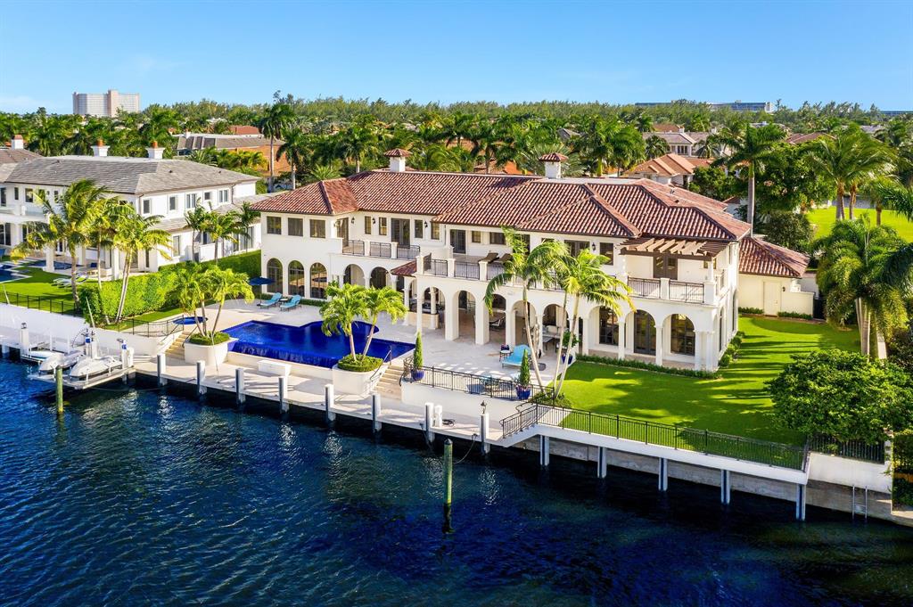 Set in the prestigious community of Royal Palm Yacht & Country Club, 191 W Key Palm Road is an impeccable Palm Beach style mansion set on an extraordinary 150ft of waterfront. Flawlessly updated in a transitional design style, the estate's details play beautifully against a sprawling two-story setting—more than 10,000 living square feet, including seven bedrooms. The exterior space, equally formidable given that it's nearly double the standard lot size, beckons to boaters with some 150 feet of deep-water dockage on the neighborhood's grand canal, just a stone's throw from Royal Palm's world-class marina. The reimagined interior honors its exquisite quality —think original, deep-grained wood flooring, lending a sophisticated contrast to the bright white living spaces on the main floor. However, the estate also soars with contemporary flourishes, like a home automation system, lighting system, an elevator, a movie theater, and a fitness room. A gourmet chef's kitchen with two elongated islands extends the interior drama with custom-designed white cabinetry and state-of-the-art appliances. Other highlights include a wine cellar, a club room with a wet bar, and an artfully conceived office space with custom cabinets and stunning inset shelving. The spacious master bedroom (with a separate sitting room/living space) opens to a balcony overlooking the canal that runs across the entire second floor. A resort-style pool with an overflow waterfall feature is the centerpiece of an outdoor environment that's built for entertaining. Loggia spaces with striking wood ceilings along the main floor provide cover for a summer kitchen, dining area and outdoor bar. There's even a cabana bath with a side entrance. Built by SRD Corp and architecture by John D. Conway. Don't miss 191 W. Key Palm Roada sight to behold against an exclusive residential backdrop.