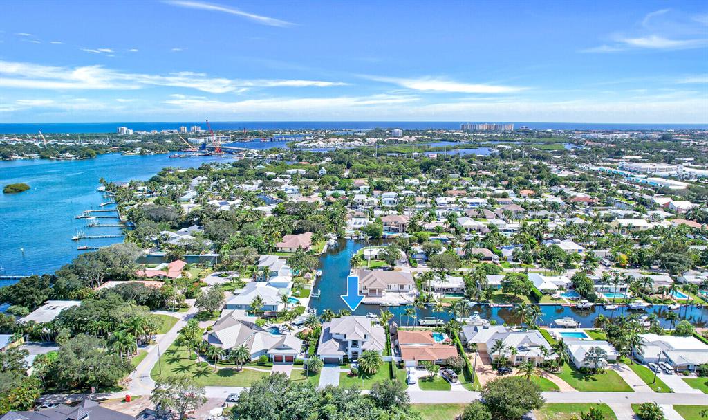 Welcome to paradise with this brand new, coastal contemporary waterfront home located on a deep-water canal with easy ocean access. Park your boat behind this 2-story house that boasts long, expansive water views with 85' of waterfront and a private 65' dock with a 12,000 lb. hi-tide boat lift. Featuring concrete construction & impact windows and doors throughout, this sprawling 3,450 sqft of living residence was impeccably constructed with the finest design, craftsmanship, and functionality in mind. Enter this 3 bedroom + a loft, 3.5 bath, pool home, and marvel at the soaring ceilings, the oversized window and doors providing an abundance of natural light, the open floor plan, and the gorgeous white European 8' wide oak floors with a steel brushed finish.
Please see additional remarks... No expense spared, additional high-quality features include custom cabinetry throughout by Woodlife Custom Cabinetry, dolomite, porcelain and granite counters, custom closets in every bedroom, Subzero, Wolf, and Cove appliances, central vacuum, bathrooms with custom porcelain & ceramic tile with frameless glass shower enclosures, plantation shutters, designer light fixtures, electronic roller shades, custom sheers on all windows, and much more. 
An entertainer's dream, enjoy this resort-style backyard with water views, a custom-designed heated pool with spa and sun-shelf, a covered patio with a full summer kitchen, a turfed backyard with a fire pit, an outdoor shower, and lush tropical landscaping. Other highlights include an oversized 2-car garage, 2 attic storage spaces, concrete slate color pavers on the driveway and walkway, cypress wood exterior ceilings, high-end security systems, 2 Navien tankless propane water heaters, 500-gallon underground propane gas tank, a smart house automation electrical system, and more. This no HOA home is conveniently located to great restaurants, shopping, marinas, pristine beaches, and the Jupiter Inlet. Top-rated Palm Beach County school district, close to Roger Dean Stadium, and very accessible to PBI Airport.  This home's furnishings are negotiable with upscale, and coastal contemporary decor.