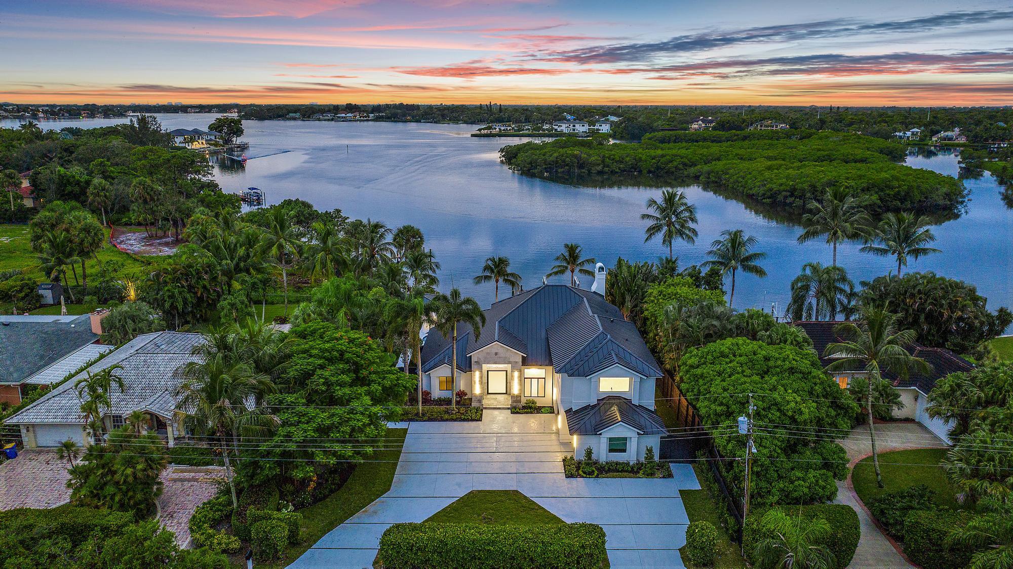 Wide Water River View - Wake up everyday to one of the most long and serene Loxahatchee River Views.  This home has been updated and renovated.   The moment you enter you will see Paradise that is River living.  Enjoy the River Life poolside with your infinity edge pool and spa, outdoor patio, summer kitchen and putting green, dock with lift and a bonus water entry for launching water crafts.   Chef's kitchen with quartz countertops, stainless appliances,  white cabinetry,  dining room with wine wall  and chillers.  Spectacular River views from the Primary Bedroom with balcony, huge walk-in closet, dual sinks and tons of natural light.   This home will not disappoint.