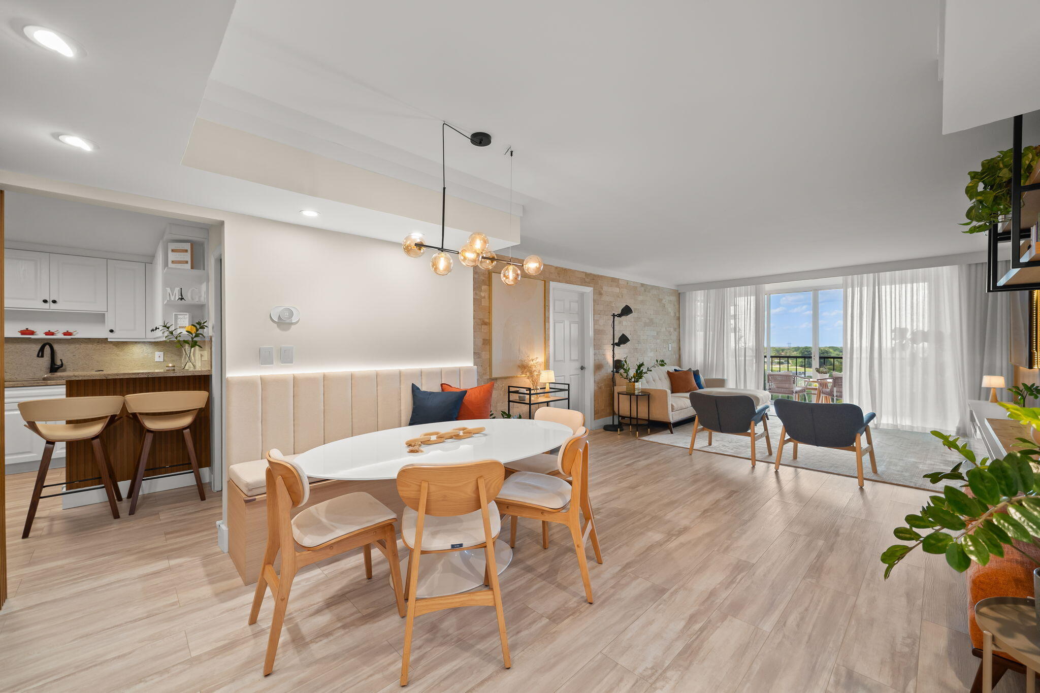 Stunning 8th-Floor Condo | Panoramic Views. Fully move-in ready Professionally designed by a Brazilian architect. Every detail has been thoughtfully curated, so all you have to do is arrive. 2 bedrooms and 2.5 blends boho-chic warmth with modern minimalism — featuring the best sunset views in the building. Premium vinyl flooring, custom wood-slatted accent walls, stone countertops, and high-end Samsung Smart appliances set the tone throughout. The hidden powder room door disappears seamlessly into the paneling. Full smart home: voice-controlled lighting and climate via any smart , and app-monitored appliances.  Patio featuring floor-to-ceiling glass with sweeping green views, a custom built-in bar with wine cooler, LED-lit floating shelves, a dedicated  and a suspended rattan lounge chair.