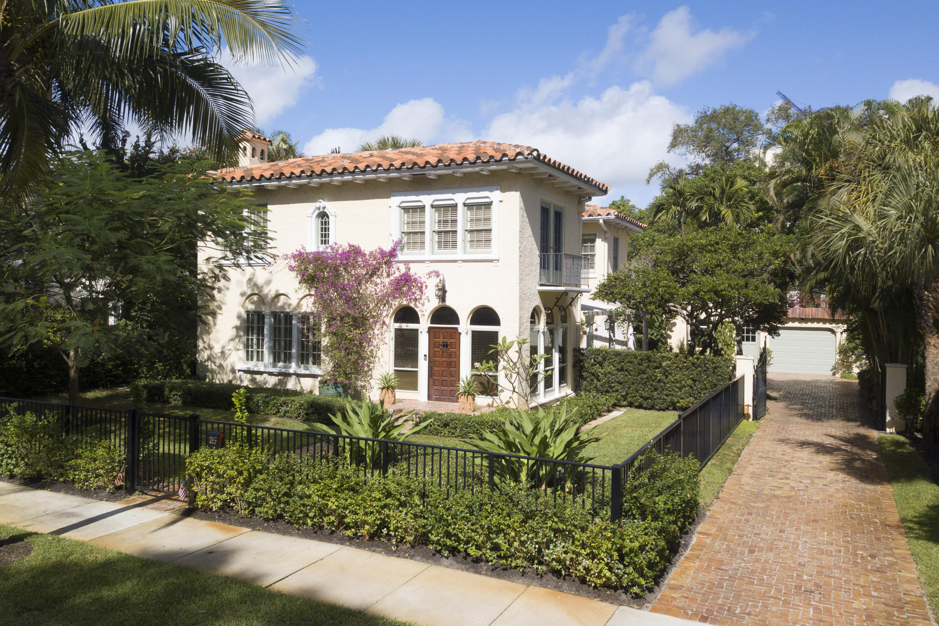 A feeling of sophistication and elegance abounds throughout this fabulous El Cid masterpiece. Located on the Lake block with Intracoastal views, this home has been cleverly updated to retain the charm and uniqueness of the roaring 20's while incorporating the best of modern components, far exceeding today's expectations. Spacious rooms with soaring ceilings, leaded glass windows with ornate hardware, a cast stone fireplace, a dual staircase, and museum quality hardwood with decorative floors all work harmoniously to make this home spectacular. The gourmet kitchen has been completely redesigned with custom cabinets, custom lighting, beautiful marble countertops, and the finest appliances all co-existing with the original architectural details from the Mizner era, leaving nothing to the imagination. The large master suite boasts a fabulous bath plus large closet.
A colorful Chicago brick driveway guides you through electronic gates to a spacious garage and two-story guest house. Duplicating the style and grace of the main house, the 1 bedroom, 1 bath guest house provides the ultimate in privacy with a full kitchen with dining area, a living room plus a spacious garage. Open and covered patios perfectly positioned throughout the property maximize the visual experience that historic El Cid is famous for.