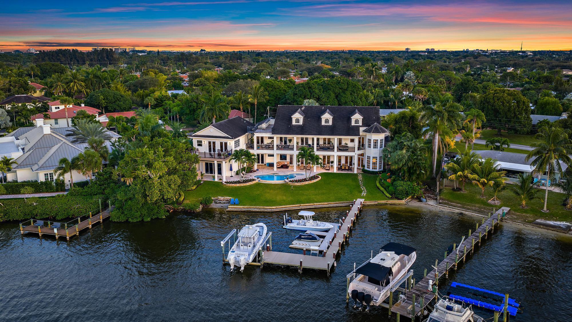 Discover this magnificent custom estate on the Loxahatchee River, featuring stunning waterfront views and breathtaking sunsets. With 7,900 sq. ft. of luxurious living space across three levels, this home boasts 6 bedrooms, 7.1 baths, and a private guest suite, complete with an elevator for your convenience. Step into the grand foyer with a floating staircase, leading to elegant formal living and dining rooms, a gourmet kitchen with a butler's pantry, and a family room with a stylish bar. Enjoy leisure time in the billiard room or serene moments in the study/library. This estate showcases exceptional craftsmanship, including an exquisite remodel of the primary suite and bath, featuring an opulent custom dressing suite. The newly updated garage includes a gymnasium with water views, and the third level offers ample space for various uses, making it a versatile part of the home. For added comfort and versatility, the estate includes a generously sized attached guest home with a private entrance, boasting its own kitchen, living room, bedroom, and bath. Ideal for boat enthusiasts, the property boasts a private dock equipped with a 24,000-pound boat lift, allowing for easy access to the water. It's just a short ride to the Jupiter Inlet, where you can enjoy excellent fishing and dining at several top-notch restaurants in the area. 2026 Slate Roof has been installed. Seize the opportunity to own this waterfront paradise!