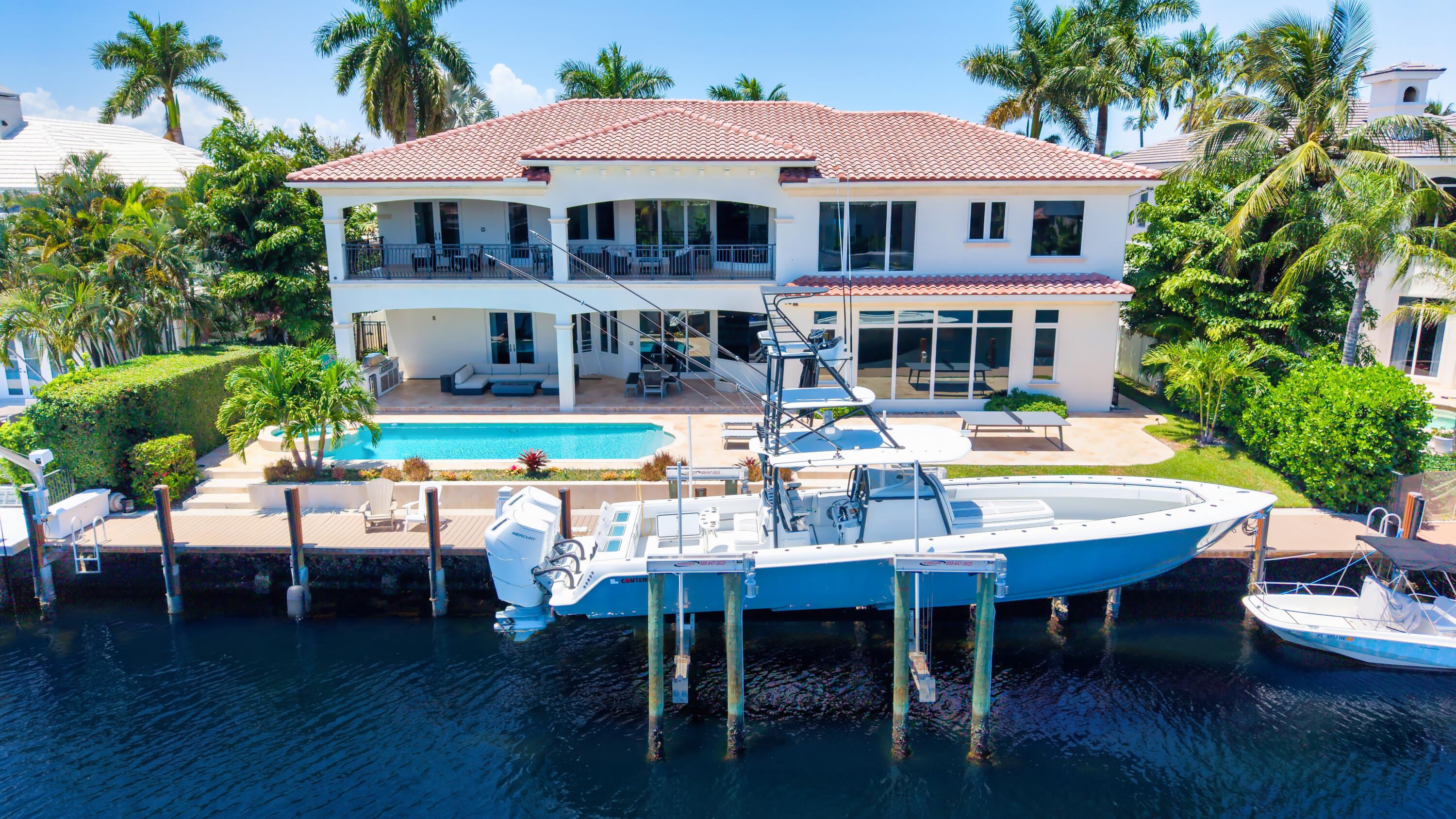 Ensconced in the prestigious yachting enclave of Lighthouse Point, this custom deepwater estate is a masterpiece sited on 100' of waterfront with rare wide water views. Masterfully crafted by renowned builder Summit Builders of Florida, the residence showcases soaring ceilings, updated interiors, and light-filled living spaces. Exceptional amenities include a 48kW gas generator, custom paneled elevator, whole-house water filtration system, security cameras, and more. Designed for effortless indoor-outdoor living, enjoy an expansive covered patio, second-floor balcony, and resort-style heated pool with a spillover spa. Ideal for the avid boater, the 100' composite yacht dock features a 32,000-lb boat lift and offers quick access to the Hillsboro Inlet. Shown by appointment only.