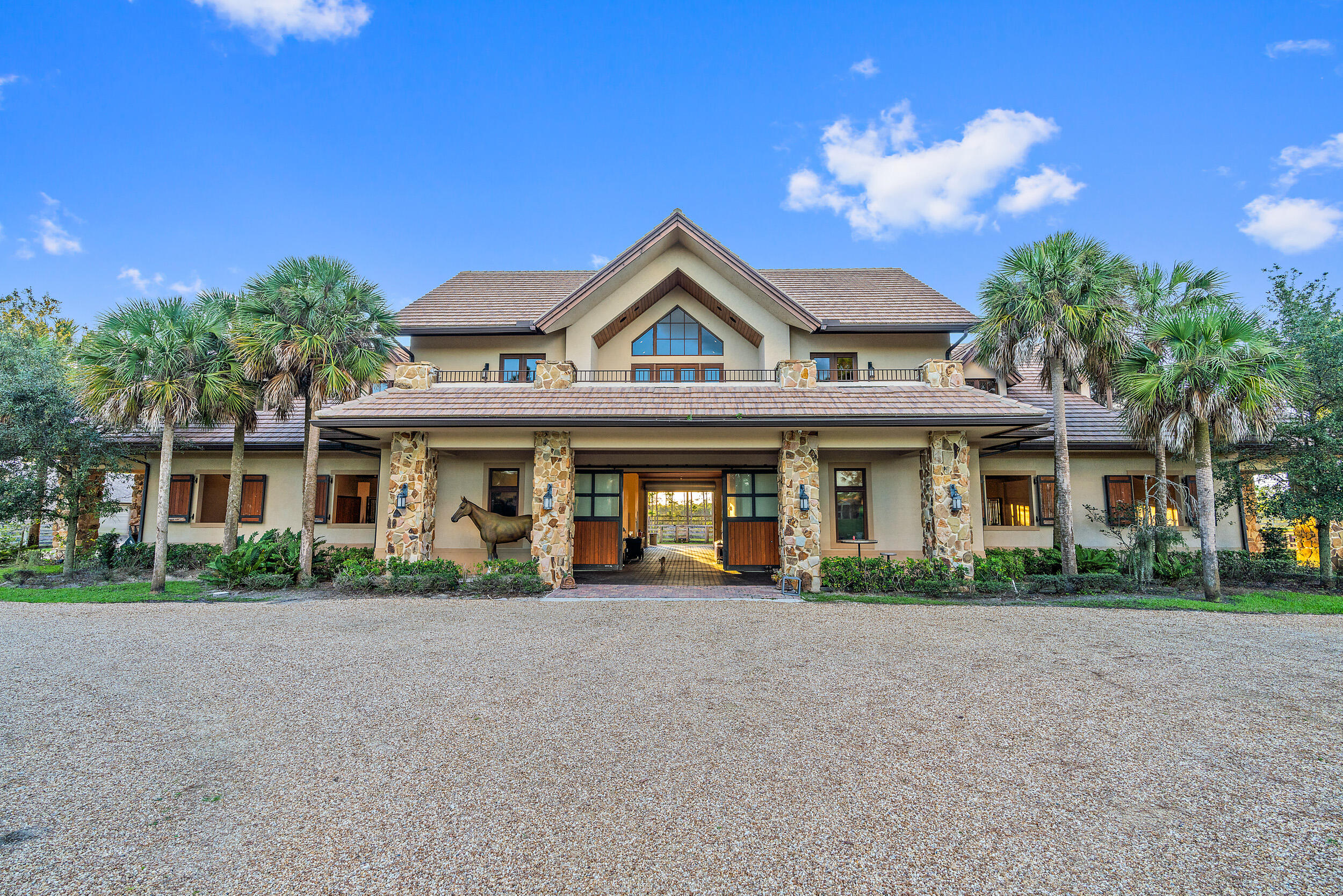 Discover Jupiter's hidden gem, perfect for privacy-seekers, nature lovers and equestrians alike. Seize the rare opportunity to build your custom dream home on this exquisite, ready-to-build property located inside Ranch Colony's Estate subdivision. 
Nestled between preserves this beautifully manicured 20-acre property is one of the driest lots available.  
Enter this private property through gated entrance with tall hedges and down a winding 8'' reinforced concrete driveway through breathtaking landscape and beautiful ponds, bridge, and white sand 'beach'.
Experience the pinnacle of equestrian luxury inside the main barn featuring 10 oversized 15' x 16' stalls.  This hurricane rated Show Barn is equipped with state-of-the-art features including: commercial fire system, comfort stall mats, individually controlled stall fans, auto waterers, and a fly spray system throughout. Additional amenities include a spacious tack room with a rotating wall, rubber pavers, multiple wash racks with hot/cold water, Kohler generator and a commercial RO System.
Two secondary barns offer an additional eight stalls with fly spray system. 
Secondary building offers a climate-controlled hay room, and 2 additional built out rooms for storage. 
Property features extensive Centaur Equestrian fencing throughout, 10 large paddocks with run-in shelters and RO water to each paddock. 
Equestrian amenities include a 120' x 220' arena with jumps, a 60' round pen, and excellent drainage with full irrigation.
Don't miss the 2-bedroom/2 bath guest house with vaulted ceilings, full kitchen, laundry room, office and a large balcony overlooking breathtaking views. Ideal for guests or as a residence during construction. 
Don't miss this rare opportunity to own a meticulously maintained property in Ranch Colony, where luxury meets the equestrian lifestyle.