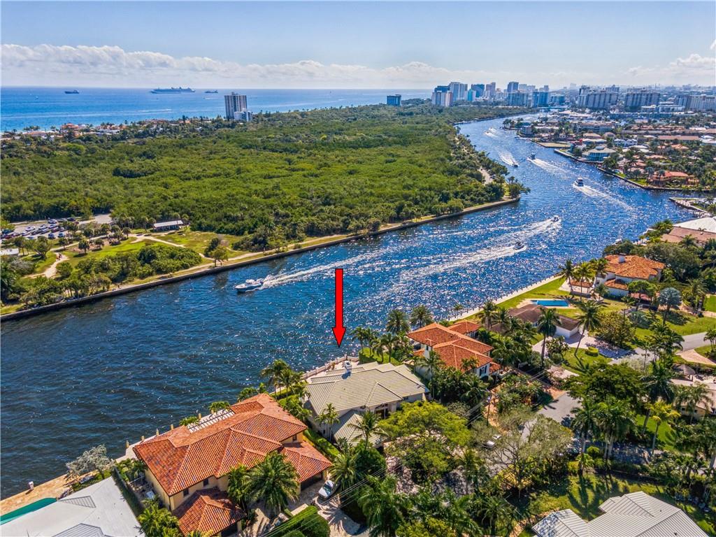 Majestic & gated Intracoastal residence located on the most sought-after & prestigious street in Coral Ridge! Spectacular direct Intracoastal & park views from the moment you step inside. Soaring 20 ft. ceilings & a rich combination of beautiful marble & wood flooring in the living areas, spacious great room w/ coral stone fireplace,  family/media room & wet bar all offer these stunning views. Gorgeous updated kitchen (2011) w/ custom wood cabinetry, granite counters & high-end appliances such as Miele, Wolf gas range & Sub Zero fridge/freezer. 2nd floor deluxe primary bedroom suite w/ sitting area, luxurious spa-like bathroom & private ICW viewing balcony. Amazing, East facing, resort style pool/spa w/ ample room to relax & enjoy the constant boat parade in your own back yard.