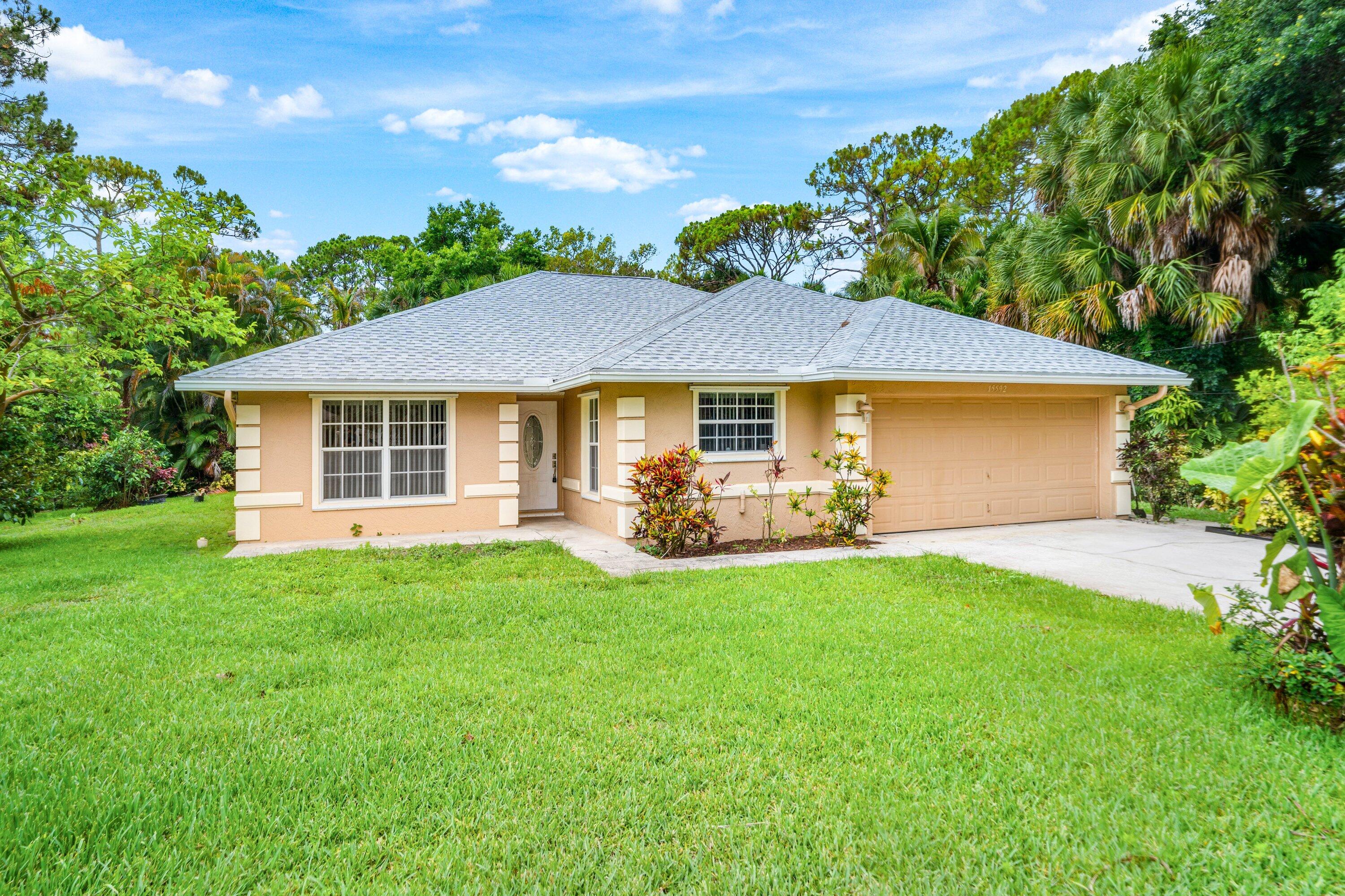 Discover the perfect blend of comfort, space, and modern updates at 15592 99th Street N in West Palm Beach. Nestled on a spacious lot in the desirable Acreage community, this well-maintained home offers the privacy and freedom of country living with convenient access to shopping, dining, and A-rated schools. Step inside to an inviting open-concept floor plan featuring soaring vaulted ceilings, abundant natural light, and durable tile flooring throughout the main living areas and bedrooms. The spacious layout is ideal for both everyday living and entertaining, seamlessly connecting the living room, dining area, and kitchen. The kitchen is equipped with real wood cabinets and newer appliances, providing modern convenience and functionality for today's homeowner.  The home's generously sized bedrooms offer comfort and flexibility, with ample space for family, guests, or a home office. Large windows throughout create a bright and airy atmosphere while showcasing views of the surrounding property. Outside, enjoy your own private Florida retreat with a sparkling swimming pool enclosed by a screened lanai, perfect for relaxing, entertaining, and year-round outdoor enjoyment. Recent improvements include a new roof installed in 2024, adding significant value and peace of mind. Whether you're searching for a pool home, an updated Florida property, a home with acreage, or a move-in-ready residence with major recent upgrades, 15592 99th Street N offers the space, flexibility, and lifestyle today's buyers are looking for.