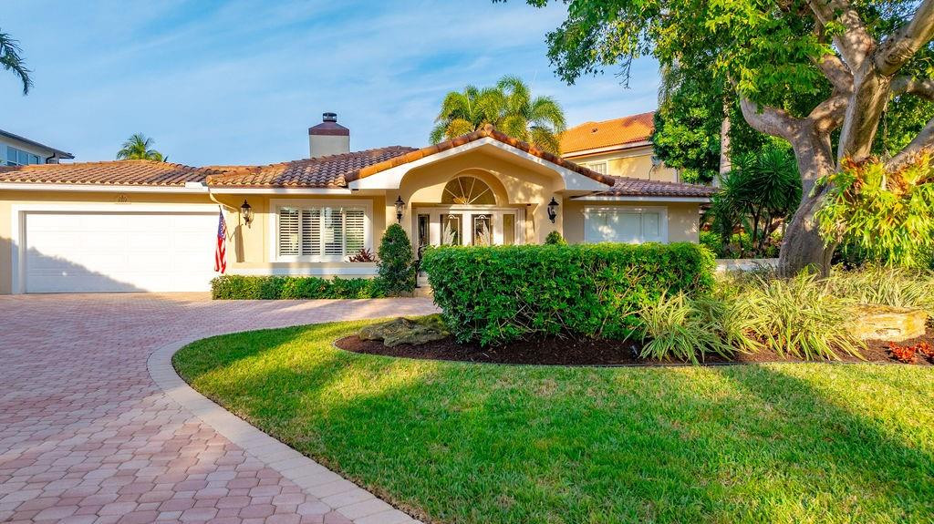 This gorgeous single-story home boasts exceptional curb appeal with a large circular drive, covered foyer entry, and lush landscaping. Ideally situated on a lovely street in what many consider the most desirable section of the City, this 3-bedroom, 3.5-bath residence features a split-bedroom floor plan and a spacious eat-in chef's kitchen. Highlights include impact glass, a cabana bath, heated pool with built-in spa, two-car garage, and air-conditioned laundry room. Perfectly positioned on a bend in the canal, enjoy refreshing breezes and tranquil water views looking toward Lake Placid. From your dock, cruise east through Lake Placid past the marina and reach the ocean in under 10 minutes.