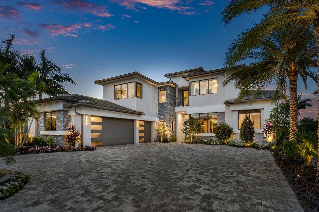 Welcome to this stunning and completely modern 5 BD/6 BA/2 HB estate home situated lakeside in the highly coveted Boca Bridges community. Every detail in this home has been hand-selected, from the exquisite wallpaper to the artistic light fixtures - not one corner was left untouched.
As you enter, you'll be immediately greeted by a glass-enclosed wine room with plenty of space to socialize and lounge with friends and family. The brand new kitchen boasts a gas stove and is perfect for the most discerning of chefs. Relax and unwind in the family room next to the beautiful fireplace.
Entertainment options abound in this home, with a dedicated home theatre, an upstairs loft that serves as a lounge, and a home gym for fitness enthusiasts. The office features custom-built ins, perfect for those who work from home.
The backyard is an incredible oasis, bedecked in a mix of marble tiles and astro turf, comparable only to a 5-star resort. The heated pool and spa with a sun-shelf for lounge chairs overlooks the putting green and lakeviews. The outdoor living spaces include an outdoor kitchen and living room equipped with electric shades, an outdoor dining room with a marble fireplace and green wall, and a third socializing space - perfect for hosting guests or just enjoying the serene environment.