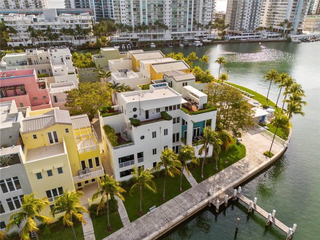 Experience elevated Miami Beach living in this luxurious 4-story townhouse located in one of the area’s most exclusive gated waterfront communities. Just a short walk to the ocean, this expansive residence boasts 5 bedrooms, 5.5 bathrooms, over 5,349 sq ft of AC living space (over 8,000 sf+ total), soaring 22-ft ceilings, and an elevator to all floors. Enjoy 4 private terraces, a private dock with Ocean access for up to 40ft boat, 2-car garage, and full valet service. Designed for the modern lifestyle, it features sleek finishes, generous natural light. Community offers 24/7 security, 2 pools, fitness center and much more. An exceptional opportunity for those seeking privacy, comfort, and effortless elegance by the beach.