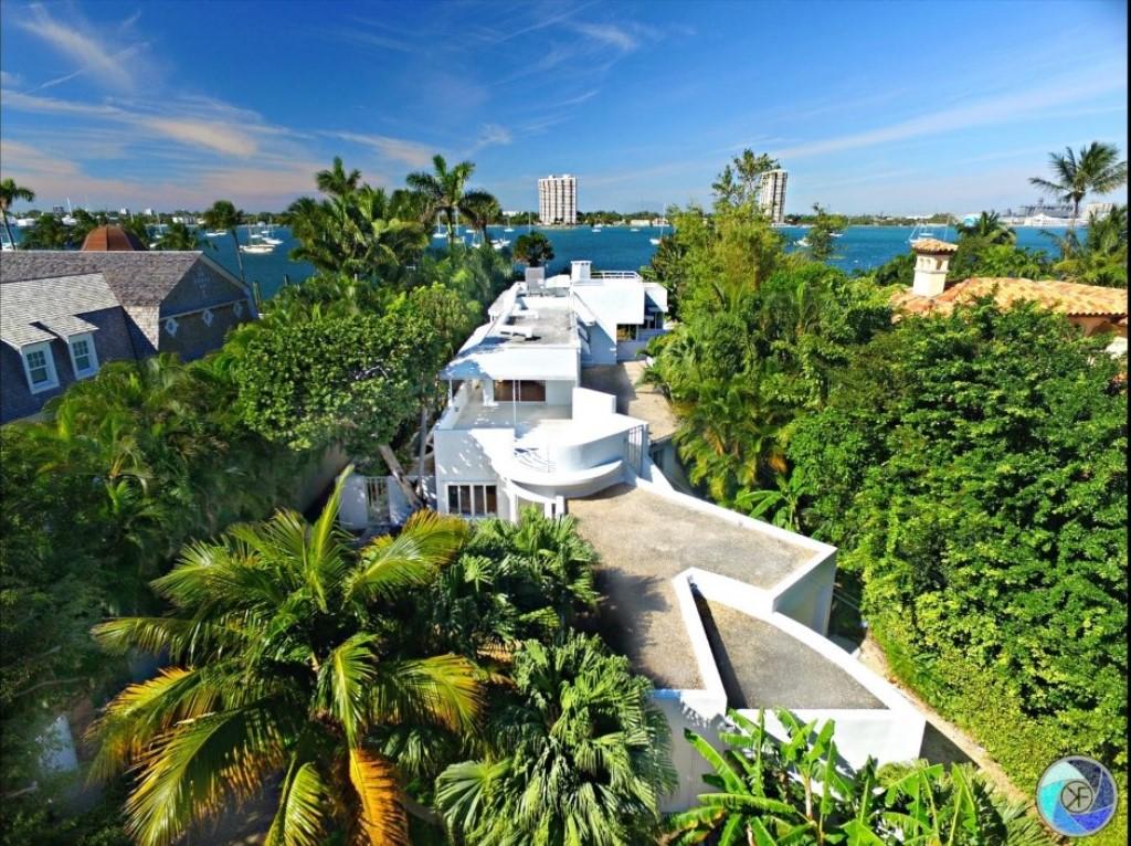 1221 North Lake Way was built in 1940 and designed by Belford Shoumate who was the most popular architect of Modernism on the island of Palm Beach. 

Designed as a 6,000 SF ‘Nautical Mansion’ the ‘Fore and Aft House’ was featured in the 1939 World’s Fair as one of the Houses of Tomorrow.  That fair had a lasting influence on American Architecture.

Following Art Deco, the International Style of Architecture grew out of a fascination with industrial design and speed, particularly, automobiles, trains, boats and planes.  The southern elevation of the 1221 has concrete porthole columns that repeat along the windowed curtain wall and the upper decks feature steamship railings. The extreme right of the house (eastern elevation) has a 2-car Y shaped garage with 2 exits. The Extreme left side (west) features the musical-key note pool overlooking the Intracoastal view, thus The Fore and Aft house. 

The house sits on 65 feet of Intracoastal frontage offering stunning views and amazing sunsets as well as a deep-water dock.  The nautical-like design has the effect of a boat, sitting on the lot overlooking the Intracoastal. Equally important, 1221 is the only Lakefront house in Palm Beach with its own deeded Oceanfront cabana down the block.

Most original details remain, including some custom furnishings.  'Fore and Aft' was designed with 4 bedrooms with exterior doors to enter and exit the exterior decks, not unlike steamships of the day.  Many of the original bathroom details remain and missing elements could be found or restored.
