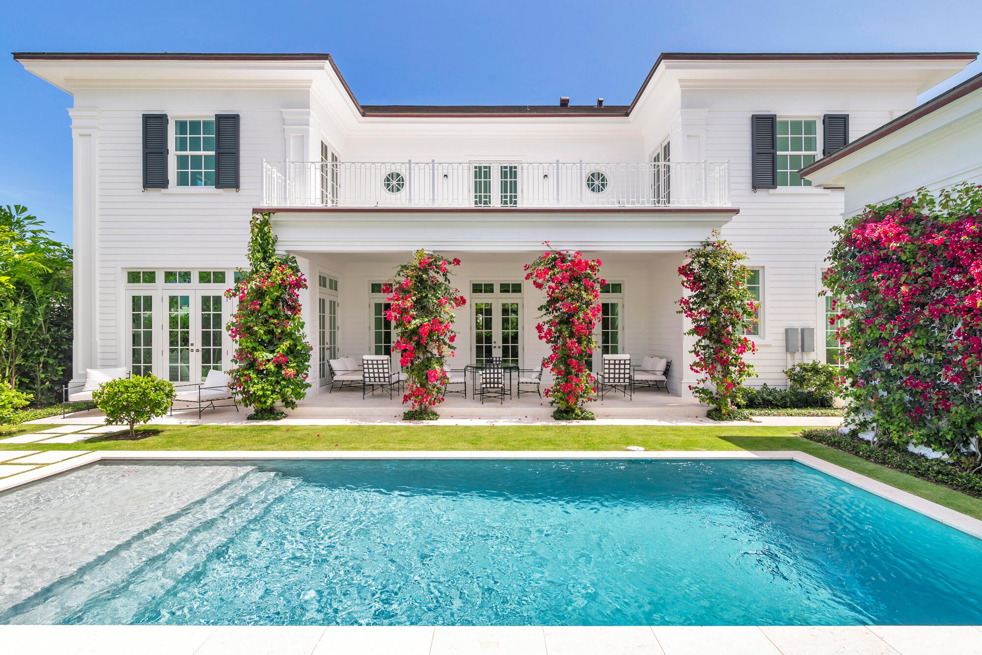 Located in West Palm Beach, this newly built residence was designed by architect Kristin Kellogg and built by the Cury Group. Featuring five bedrooms, five full bathrooms, and one half bath, with 5,360 square feet under air and a total of 6,106 square feet. At the center of the home is a spacious living room with a fireplace as its focal point. Large doors open to a deep covered loggia, creating a seamless indoor-outdoor space. The backyard features a resort-style pool with a sun shelf, surrounded by landscaping designed by renowned architect Mario Nievera. Off of the living room, two additional rooms offer flexibility for a formal dining room, media room, or office. The gourmet eat-in kitchen offers a built-in banquette for casual dining and is equipped with top-of-the-line appliances, including a Sub Zero refrigerator and freezer, a Cove dishwasher, a Wolf gas range with an electric oven, and a Wolf coffee maker within a dedicated coffee bar. Mystery White Marble countertops and unlacquered brass hardware from the Massey Collection by Rejuvenation add a refined touch. The primary suite opens to a spacious terrace overlooking the pool and features two walk-in closets, dual sinks, a soaking tub, a walk-in shower, and polished nickel hardware. Three additional bedrooms are located upstairs, with two opening to the terrace. Additional features include a cabana bath, and a laundry room with dual washers and dryers and a dedicated dog wash station. Private guest quarters are located off of the kitchen with a full bath, and walk-in closet. Other amenities include an air-conditioned two-car garage with a service entrance, a full-house generator, gas pool heater, tankless hot water heaters, and a gas generator. The home is equipped with a Trane A/C system with two main units and two split systems for efficient climate control. This modern residence offers high-end living in a prime West Palm Beach location.