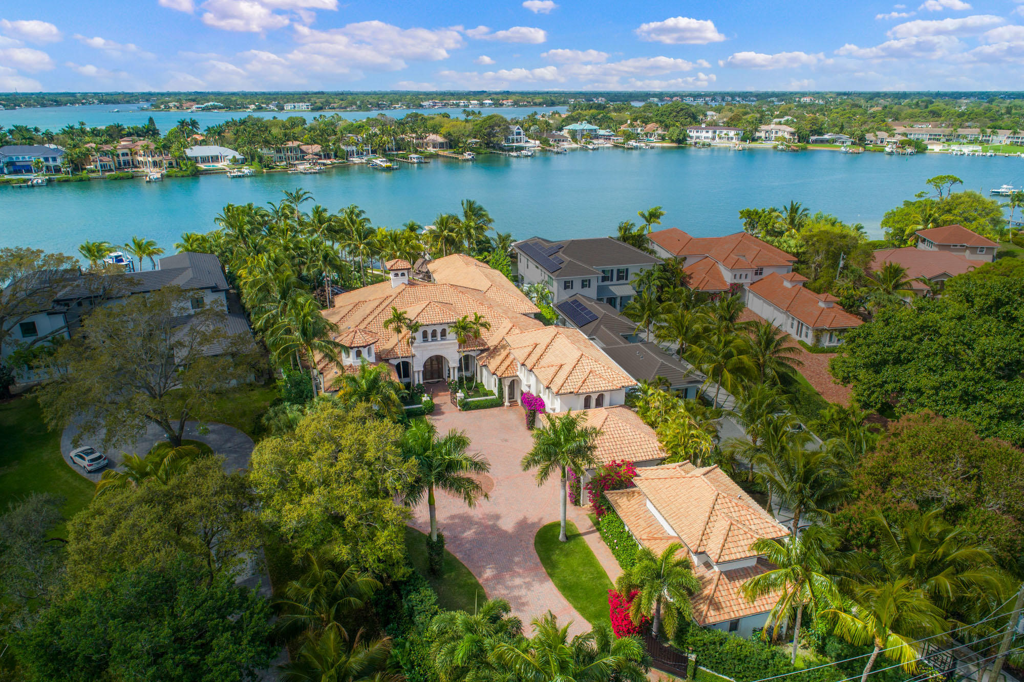 Spectacular riverfront estate on an expansive 1 acre parcel with 190' along the water! The spacious  home was built in 2003, and renovated over the last 2 years, and features over 13,000 total square feet, which includes the gracious main house that is all on 1 level except 1 guest bedroom suite, the spacious outdoor living areas, 6 car garage, and a 2 bedroom guesthouse.  As you enter the gated driveway, you are taken in by the attractive house along with the meticulous landscaping that ensures total privacy. Inside the home features an open, flowing floorplan, recently renovated Downsview kitchen, oversized natural marble throughout, spectacular views of the river, and the resort style pool and backyard. Incredible pool that meanders through the yard and cumulates with a grand water... feature, and water slide. other features include the basketball court, playground, tiki bar, dock with a slip that can accommodate up to a 50' yacht (and 4' draw), and lush landscaping. The house comes equipped with a whole house generator, a smart house with Lutron automation. Spectacular location just minutes to the ocean by boat or car, in the heart of Jupiter along the premier waterfront, yet very private and secure.