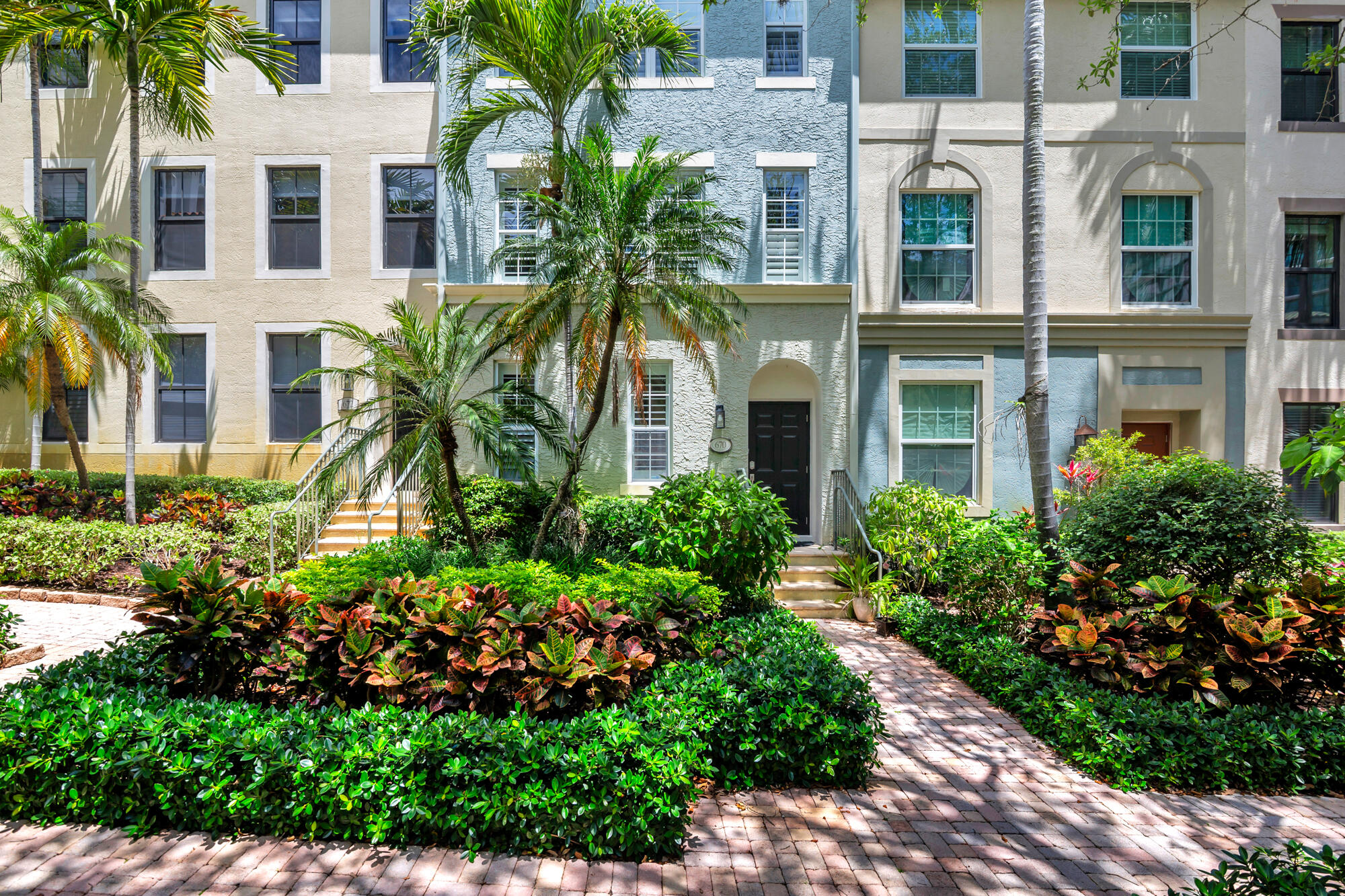 This fully renovated 3-bedroom, 3-bathroom townhome showcases a complete transformation, featuring new Quartz countertops, custom cabinetry, updated appliances, designer lighting and plumbing fixtures, millwork, elegant wallpaper, and thoughtfully selected paint finishes. A new roof has been recently installed, along with a new HVAC system in Fall 2024. Tucked within a gated, secure interior setting with no street exposure, the home offers privacy and tranquility. An attached two-car garage opens to a private, gated driveway for added convenience. Lush, well-manicured tropical landscaping and soaring palm trees welcome you each time you arrive. This courtyard-facing residence is filled with natural light thanks to its abundant windows, offering serene views of the surrounding greenery.  Ideally situated in the heart of CityPlace, the home feels like a secluded retreat while remaining steps from everything. Walkability is a key highlight of the lifestyle here, with a Publix supermarket nearby for everyday convenience. Just blocks away enjoy premier shopping, dining, and fitness options including Eataly, Equinox, Crate & Barrel, and popular restaurants such as Harry's, Adrienne's, and El Camino, among many others. The Brightline station is only three blocks to the east, while the new Vanderbilt University graduate campus is under development three blocks to the west, further enhancing the area's appeal.