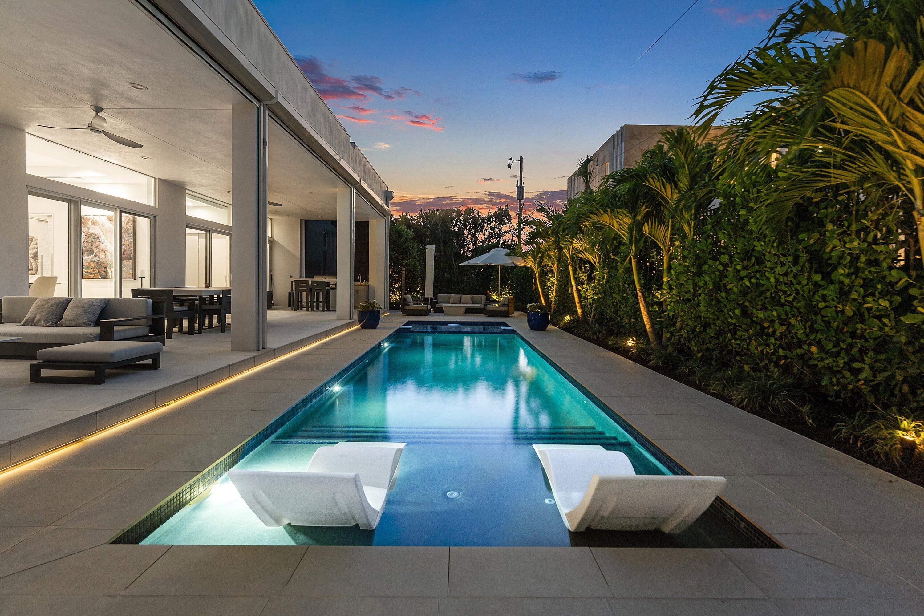 Welcome to one of the best coastal values in South Florida, located on exclusive Hypoluxo Island. This newer one-story luxury home sits on a private cul-de-sac of just six residences, offering exceptional privacy in a charming island setting. Spanning approximately 2,600 square feet, this 4-bedroom, 3-bath smart home is thoughtfully designed with soaring 11-foot ceilings, porcelain flooring, and a bright open floor plan. Expansive hurricane-impact sliding glass doors fill the home with natural light and seamlessly connect indoor living spaces to the outdoor retreat. The gourmet kitchen features top-of-the-line stainless steel appliances, an induction cooktop, marble countertops with full backsplash, German custom cabinetry, and a large center island perfect for entertaining. The spacious  primary suite offers a tray ceiling, custom closets, and a spa-like bath with dual vanities, soaking tub, and walk-in rain shower. A flexible den/office with Murphy bed easily functions as a fourth bedroom.  Step outside to a private, resort-style setting with an 800-square-foot covered patio, full outdoor kitchen, gas fireplace, and multiple entertainment areas. The gas-heated saltwater pool and spa, outdoor shower, firepit, and new putting greencomplete the ultimate South Florida outdoor lifestyle.  Additional features include a whole-house generator, two tankless gas water heaters, dual energy-efficient A/C systems, smart home technology, remote shades and hurricane screens, and a fully furnished, move-in-ready interior.  Ideally located in Palm Beach County between Palm Beach and Delray Beach, this home offers convenient access to beaches, dining, shopping, and airports—while maintaining the peace and exclusivity of island living.