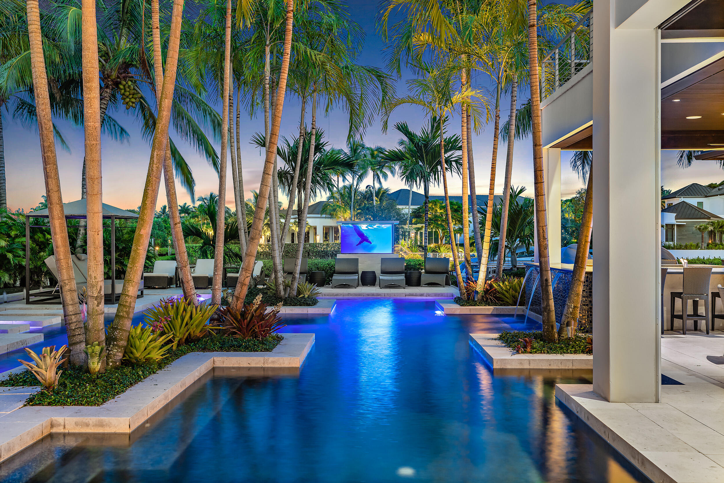 Contemporary Turtle Beach Construction Custom Waterfront Estate Home with over 120' of Water Frontage. This 5 bedroom, plus office/den home is breathtaking.  As you enter the front door you are greeted by the resort style pool, spa, water features & lounge areas, you will feel as though you are on vacation. Covered and open loggias with a pecky cypress, TV's, water shelves and a 2 sided pop up TV to view from the dock.  Custom chef's kitchen features dual islands, gas range, stainless refrigerator / freezer and cooling drawers all overlooking the family and breakfast areas. Luxurious owners retreat will have you feeling relaxed and recharged with a gas fireplace, black out shades, views of the resort pool and patio, walk-in closets, dual vanity sink, soaking tub and large walk-in shower. 1 main floor guest suite with private bath and 3 guest suites on the upper floor with private bath all opening to loft with beverage station. Second floor work out room with glass doors and entry to an expansive balcony with amazing water views. This home was built with top of the line materials, ultimate craftmanship and well thought out spaces all opening to the outdoor oasis. Artificial turf, putting area with bunker, electronic screening, lush tropical landscaping, 2 fireplaces, electric sliding doors, dock for large yacht plus a lift and 2 jet ski platforms are just a few of this homes many upgrades.