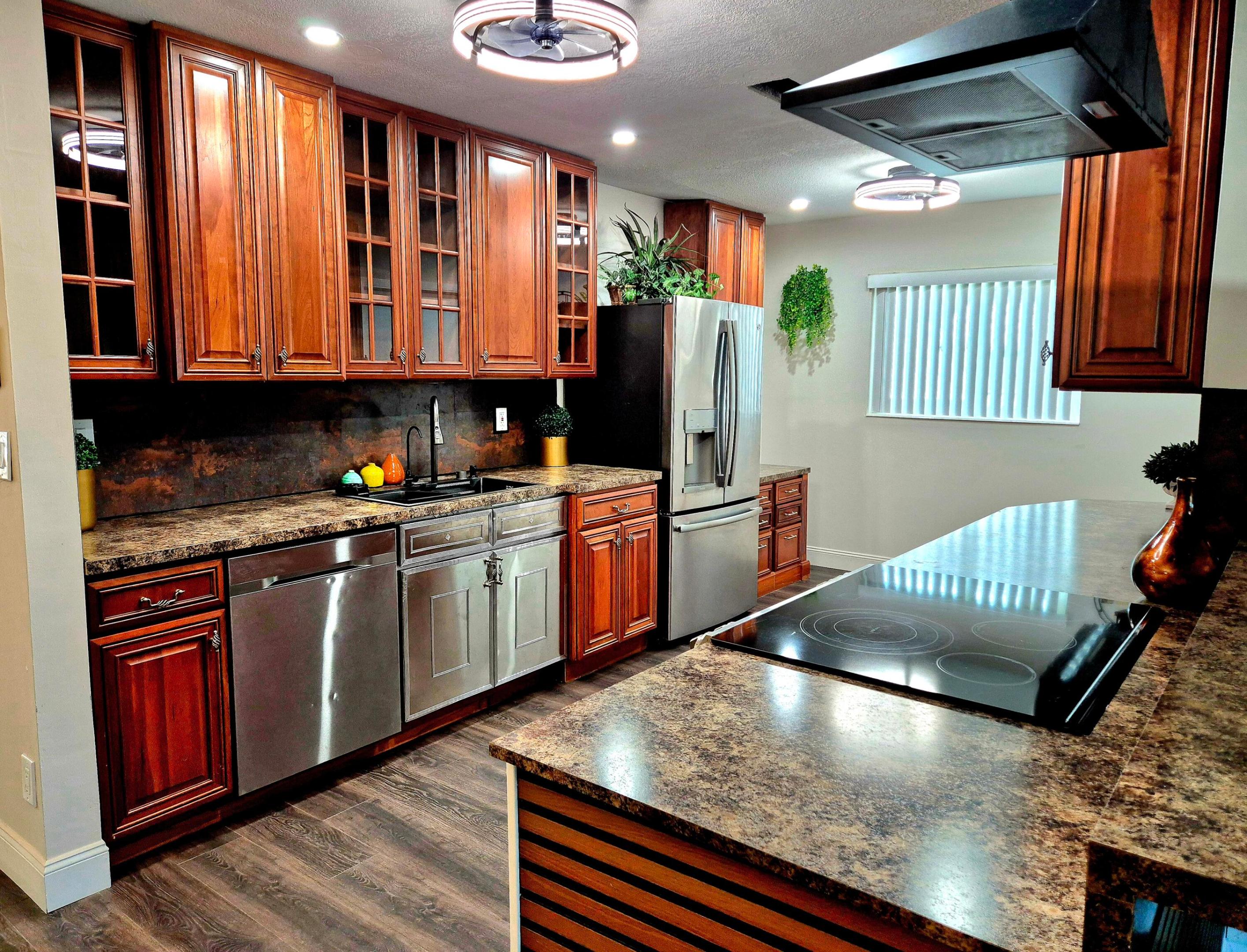 This exquisite home and spacious model with many beautifully upgraded features throughout: Dream Kitchen and appliances, 3 bedrooms and 2 baths with an office nook. It boasts an open and split floor plan, attractive laminate  flooring. New IMPACT Windows , tankless water heater, electric panel. ALL WORK WAS COMPLETED WITH PERMIT! Up to todays code! INSURANCE DISCOUNT! Beautiful designer landscaping. Private backyard really allows you to enjoy South Florida Best Lifestyle. Walking distance to clubhouse and huge parking area. You must see it before it's GONE! Enjoy very  low HOA fees, clubhouse, pool & active community amenities. Prime location close to shopping, dining, beaches & entertainment. Schedule your showing today!