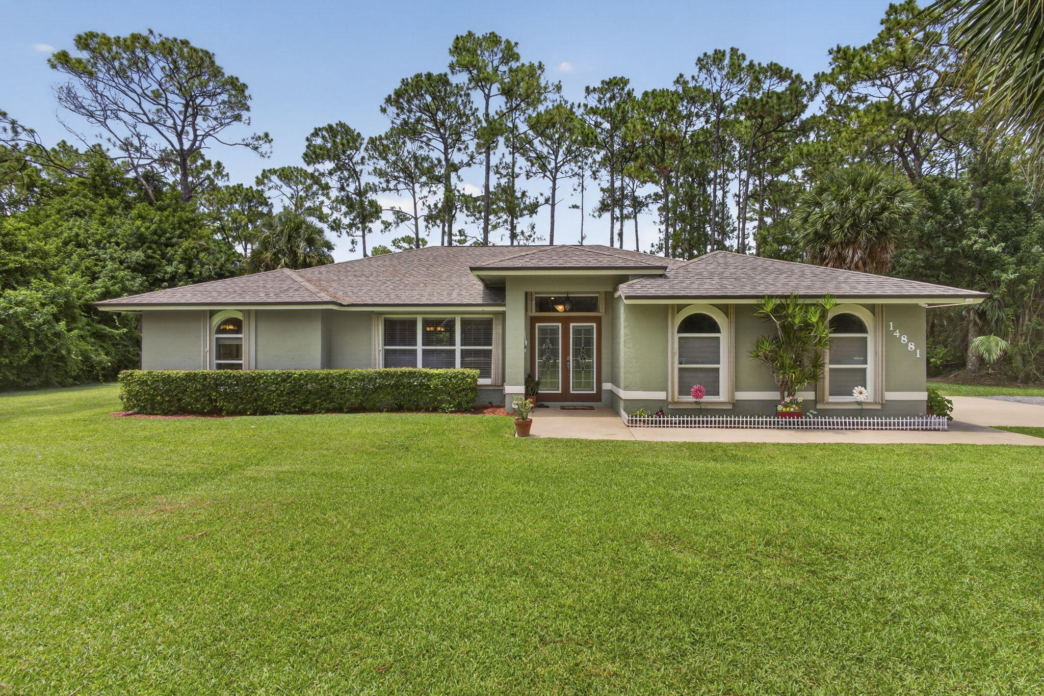 Beautifully maintained one-owner home situated on a private, fenced, wooded 1.15-acre lot with NO HOA! This spacious residence features formal living and dining rooms, walk-in closets in all 3 bedrooms, elegant travertine flooring throughout. Interior upgrades include custom window trim, and new blinds throughout, crystal cabinetry, granite countertops, newer GE stainless steel appliances. Additional highlights include new GarageTrac flooring, an extra refrigerator, and an oversized screened patio with convenient direct access to a bathroom. Newer A/C (2020) with 10-year warranty, well and water system (2022), and roof (2017). The home also features decorative impact-rated double entry doors, accordion hurricane shutters, and a high-voltage electrical hookup with power converter. Conveniently located within one mile of Publix, restaurants, shopping, gas stations, the library, an elementary school, daycare, and Acreage Community Park. Furniture negotiable. Make this home yours today!  Showings begin Monday, July 20th.