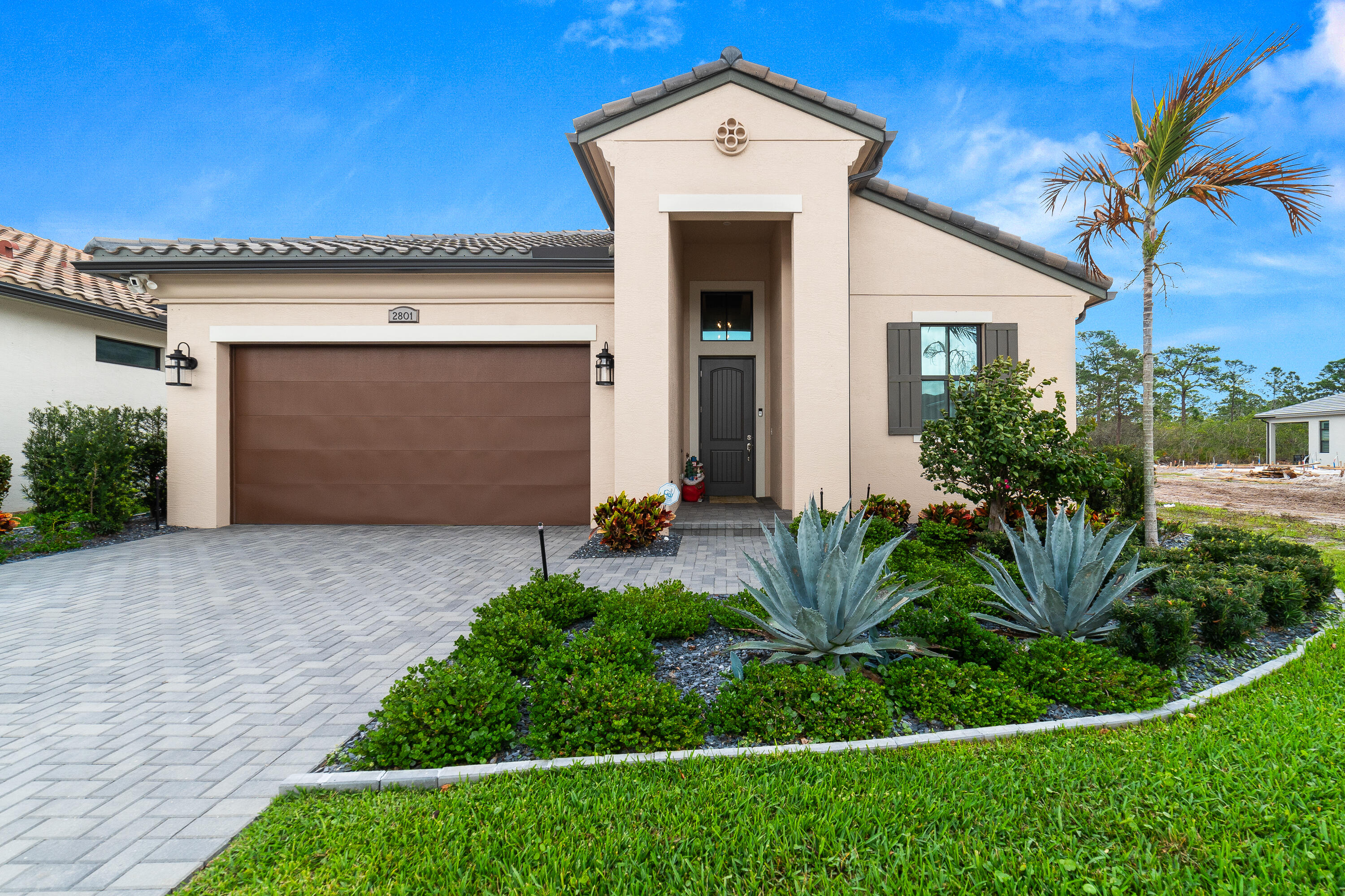 Welcome to this beautifully designed 3-bedroom, 3-bathroom residence with a spacious den that easily functions as a 4th bedroom—perfect for guests, a home office, or a growing household. Thoughtfully crafted for both comfort and style, the home features elegant ceramic tile flooring throughout the main living areas and warm laminate flooring in the bedrooms, creating a seamless blend of sophistication and ease. At the heart of the home, the chef-inspired kitchen is truly a showpiece, offering sleek quartz countertops, stainless steel appliances, a gas range, double oven, and a generous pantry for ample storage. The open-concept layout is enhanced by soaring ceilings and contemporary lighting, filling the space with natural light and an airy, modern feel that's ideal for both everyday living and entertaining. The spacious owner's suite serves as a private retreat, complete with a spa-like bathroom designed for relaxation, featuring upscale finishes and a tranquil atmosphere. Enjoy your private backyard retreat, where a premium paver patio invites you to relax and soak up the Florida sunshine, with ample space to design your future pool. The screened lanai is a standout feature, complete with an outdoor summer kitchen—perfect for hosting gatherings, enjoying evening dinners, or simply unwinding in comfort. Located in the highly sought-after Mosaic community within Veranda, residents enjoy resort-style amenities including a beautifully appointed clubhouse, sparkling community pool, and tennis courts, all set within a thoughtfully planned and vibrant neighborhood. Ideally situated just 15 miles from the pristine shores of Jensen Beach, this home offers the perfect balance of peaceful community living and coastal convenience. You're also within close proximity to shopping, dining, golf courses, parks, and major roadways, making everyday living as effortless as it is enjoyable.