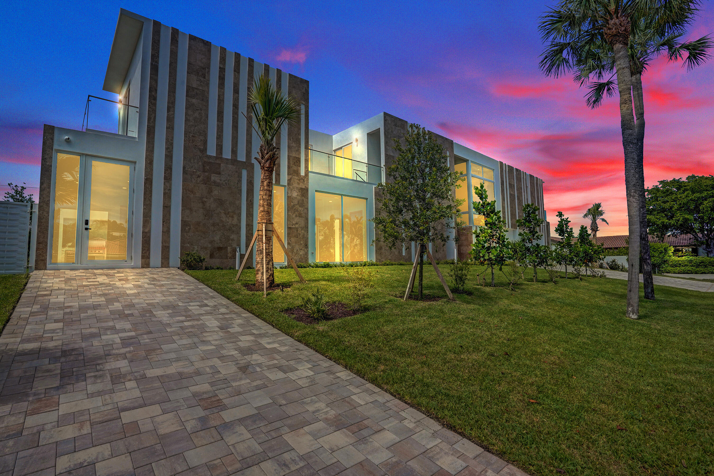 Casa Marbella — An architectural award-winning new construction contemporary estate located in the exclusive coastal community of Hypoluxo Island, one of Palm Beach County's most desirable neighborhoods. Perfectly positioned just minutes from the beach, fine dining, boutique shopping, marinas, and vibrant coastal attractions, this brand-new 6-bedroom, 5-bath smart home captures the essence of luxury Palm Beach living with timeless architecture, elegant finishes, integrated surround sound, and a true resort-style atmosphere. Designed with an expansive open-concept layout, the home welcomes you through soaring glass entryways into beautifully curated living spaces filled with natural light. Rich marble and natural stone finishes are showcased throughout, while a stunning custom staircase  creates a dramatic focal point leading to the upper level. Every detail was thoughtfully designed to blend sophistication with comfort, offering seamless indoor-outdoor living ideal for entertaining and everyday enjoyment. The luxurious primary suite serves as a private retreat featuring a grand entry, spa-inspired ambiance, private balcony, and beautiful Intracoastal views that capture the relaxed coastal lifestyle Hypoluxo Island is known for. Spacious guest accommodations and private guest quarters provide comfort and privacy. Step outside to your own tropical resort featuring a spectacular pool with spa, expansive entertaining patio, and a fully equipped outdoor kitchen designed for unforgettable gatherings. The oversized driveway and spacious 3-car garage provide both convenience and impressive curb appeal. Surrounded by beautiful coastal estates and lush tropical scenery, Casa Marbella offers an exceptional opportunity to experience the very best of Palm Beach luxury living. Just moments from pristine beaches and the Intracoastal Waterway, this remarkable residence delivers the perfect balance of modern architecture, cutting-edge smart home technology, resort-style comfort, and refined coastal elegance in one of South Florida's most sought-after island communities.