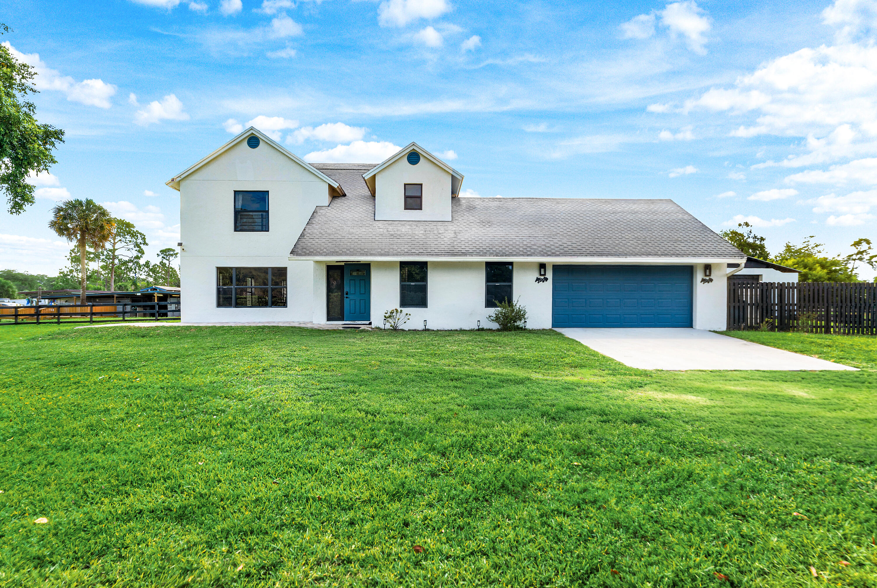 Wake to horses outside the window and ride out onto the Groves' bridle paths. This 4-bedroom, 2.5-bath modern farmhouse sits on 5 fenced acres with a private pond and a paver-deck pool. Inside, an updated kitchen with white cabinetry and a center island opens to hardwood living space, with a 2-car garage. The home rents on its own, with up to 10 stalls available for dry stall or full board separately. Loxahatchee Groves gives you the agricultural freedom most communities won't, minutes from Wellington International and the WEF showgrounds. Offered furnished or unfurnished.