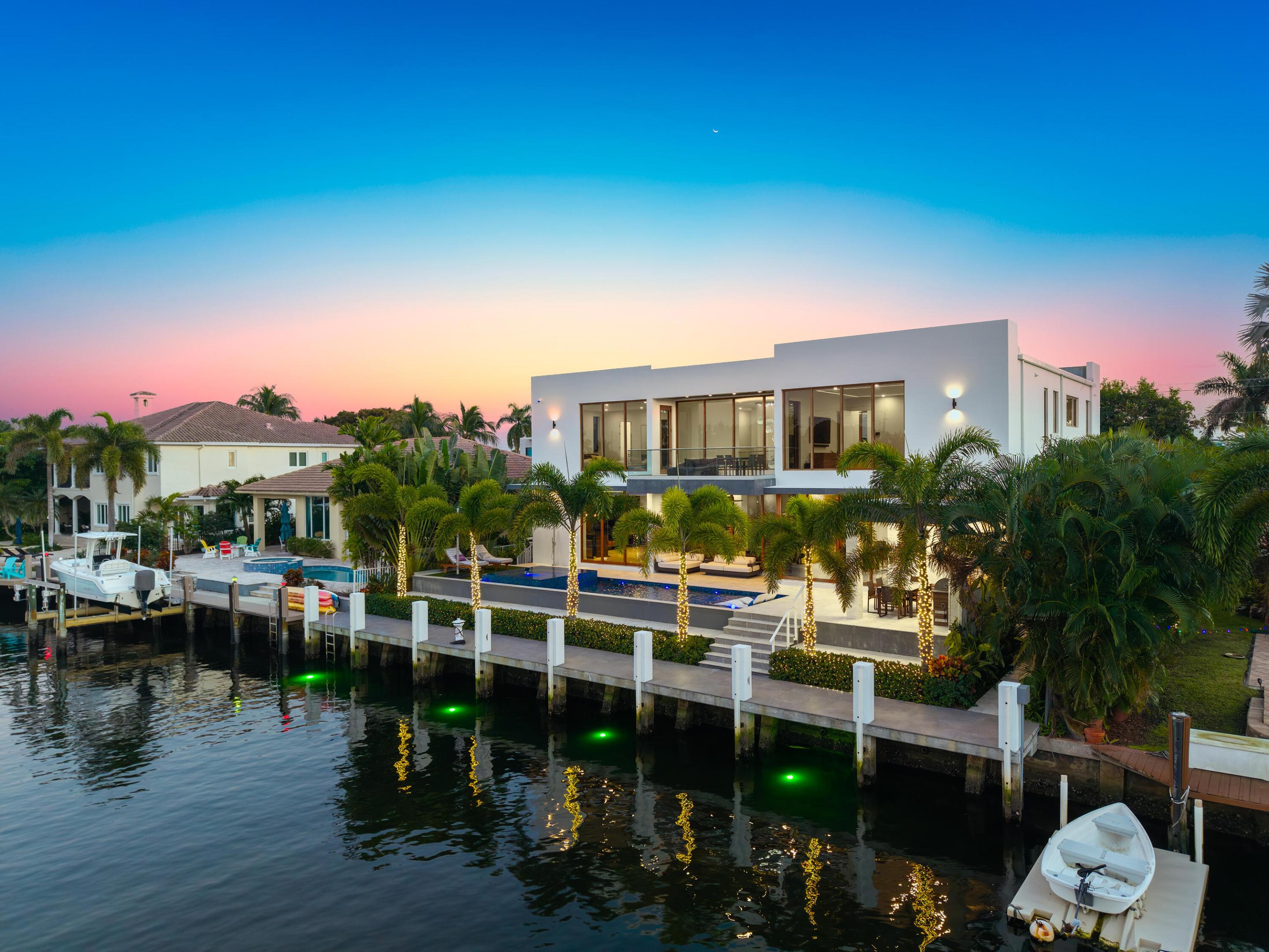Experience unparalleled modern waterfront luxury in prestigious Lighthouse Point. Completed in 2023, this exceptional contemporary estate offers 5,844 SF under A/C, 80' of prime deepwater frontage, a new private dock, and direct Intracoastal-to-ocean access with no fixed bridges. The 5BR/5.5BA residence is designed for effortless entertaining and everyday living, featuring soaring ceilings, a resort-style pool and spa, and a versatile 3-car garage with lift-ready ceilings accommodating up to 6 vehicles. A state-of-the-art smart home with voice control manages lighting, Lutron shades, locks, audio, TVs, climate, and security. Over $200K in premium upgrades include TOTO Neorest LS bidets, custom walk-in closets, commercial-grade whole-house water filtration with reverse osmosis, garage A/C,