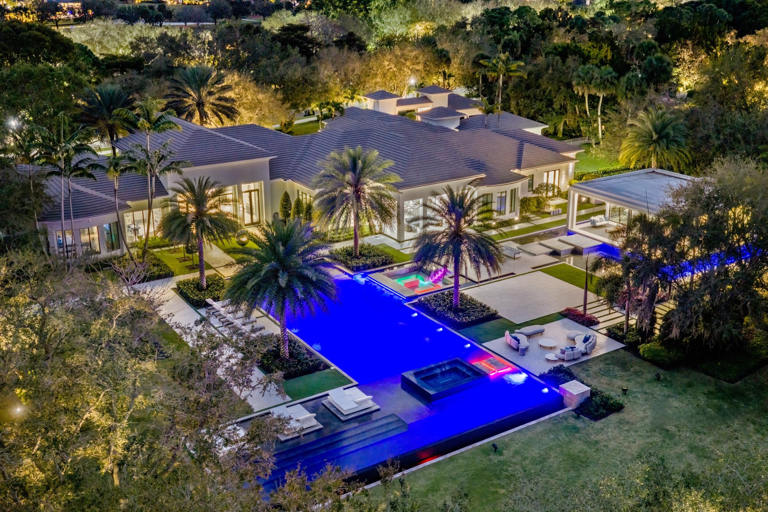 Experience a new standard of refinement at this extraordinary lakefront estate, Villa Sereno, set within Stone Creek Ranch, Delray Beach's most exclusive and meticulously curated enclave of luxury residences. Occupying a commanding 5.04-acre compound, Villa Sereno unites a pristine 2.5-acre primary homesite with an additional 2.5-acre Zen-inspired garden, offered as a singular, uninterrupted estate. The unmatched scale of the grounds creates a rare sense of seclusion and freedom, providing an expansive canvas for architectural grandeur, serene outdoor living, and a lifestyle of resort-like elegance seldom found in the enclave. Originally completed in 2008 and masterfully renovated in 2022, the estate encompasses 10,929 square feet of exquisitely reimagined interiors, where enduring architectural presence is elevated by a contemporary standard of craftsmanship, design, and finish. The expansive seven-bedroom, ten-bathroom plus powder room layout is thoughtfully composed to provide both grand entertaining proportions and an atmosphere of intimate refinement, with beautifully scaled living spaces and private retreats curated with effortless sophistication. The powder room is a study in refined materiality, where the vanity is sculpted entirely from Umbra Silver Agate, its silver veining catching the light to create a luminous, jewel-like centerpiece that defines the space with quiet elegance. A separate 988-square-foot guest house further enriches the offering, its bright, sunlit interiors providing a private and gracious haven for visitors, ensuring comfort and seclusion with understated elegance.

A grand porte cochère arrival introduces Villa Sereno with distinguished presence and a refined sense of procession, opening into luminous formal interiors enriched by vein-cut matte finished travertine and white oak, finely crafted stonework, and bespoke architectural detailing throughout. The formal dining room provides an exquisite setting for gracious entertaining, while the expansive kitchen, anchored by a luminous Taj Mahal quartzite countertop and complemented by meticulously crafted finishes, opens seamlessly to a sun-drenched breakfast area, creating a refined space for both daily living and sophisticated gatherings amidst views of the estate's tranquil grounds.

The residence is designed to support a refined and multifaceted lifestyle, featuring a private office filled with natural light, a tranquil lounge centered around a fireplace enveloped in Victoria Blue quartzite, a dedicated craft room, and a climate-controlled wine cellar thoughtfully curated for the discerning collector. A fully appointed spa, complete with an integrated salon, offers a serene retreat for wellness and rejuvenation. The seven-car garage is exceptional in both scale and craftsmanship, providing practical accommodation for everyday vehicles while also serving as an elegant venue for displaying a curated automotive collection, combining utility with understated grandeur.

The primary suite serves as a sanctuary of refined repose, defined by generous proportions and an enduring sense of tranquility. Its two baths are composed in exquisite contrast: hers enveloped in the luminous translucence of Cristallo quartzite, where soft, pale tones create an atmosphere of serene delicacy, while his is defined by the richly veined depth of Arabescato Orobico Grigio marble, imparting a mood of quiet strength and enduring sophistication. The suite's expansive custom closet, secured by a discreet biometric scanner, combines privacy with exacting craftsmanship. 
Every element of the primary suite has been thoughtfully composed, resulting in a harmonious environment that seamlessly unites elegance, functionality, and restrained sophistication.

Encompassing approximately 565 feet of waterfront, the estate is beautifully positioned to enjoy golden sunset light across the tranquil lake. An oversized saltwater pool and spa, framed in leathered Platino quartzite, provide a serene focal point, surrounded by manicured landscaping and expansive outdoor space suited for both sophisticated entertaining and moments of quiet repose.

The additional Zen-inspired garden parcel unfolds as a rare and extraordinary amenity--an expansive sanctuary that transforms the property into a generational compound. Whether envisioned as a meditative escape, sculpture garden, or future expansion opportunity, this sprawling green space offers limitless potential and unmatched serenity.

Set within the prestigious confines of Stone Creek Ranch--renowned for its oversized estates, uncompromising privacy, and world-class setting--this property represents a singular opportunity to own one of South Florida's most distinctive luxury offerings, just minutes from Delray Beach's celebrated dining, shopping, and coastline.

A privileged retreat. A rare double-lot lakefront estate. An exceptional place to call home, welcome to Villa Sereno.