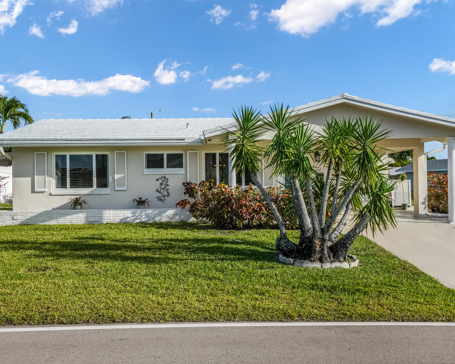 Beautiful oversized corner lot home in 55+ Mainlands of Tamarac. Ceramic tile throughout for easy care, with granite countertops in the kitchen. Enclosed Florida room adds versatile living space. Impact windows throughout provide peace of mind and energy efficiency. Enjoy plentiful outdoor space in the front, back, and under the carport—perfect for relaxation or entertaining. Recent upgrades include AC (2025) and water heater (2026). This peaceful, well-maintained home is ready for you to make it your own. Schedule a showing today.