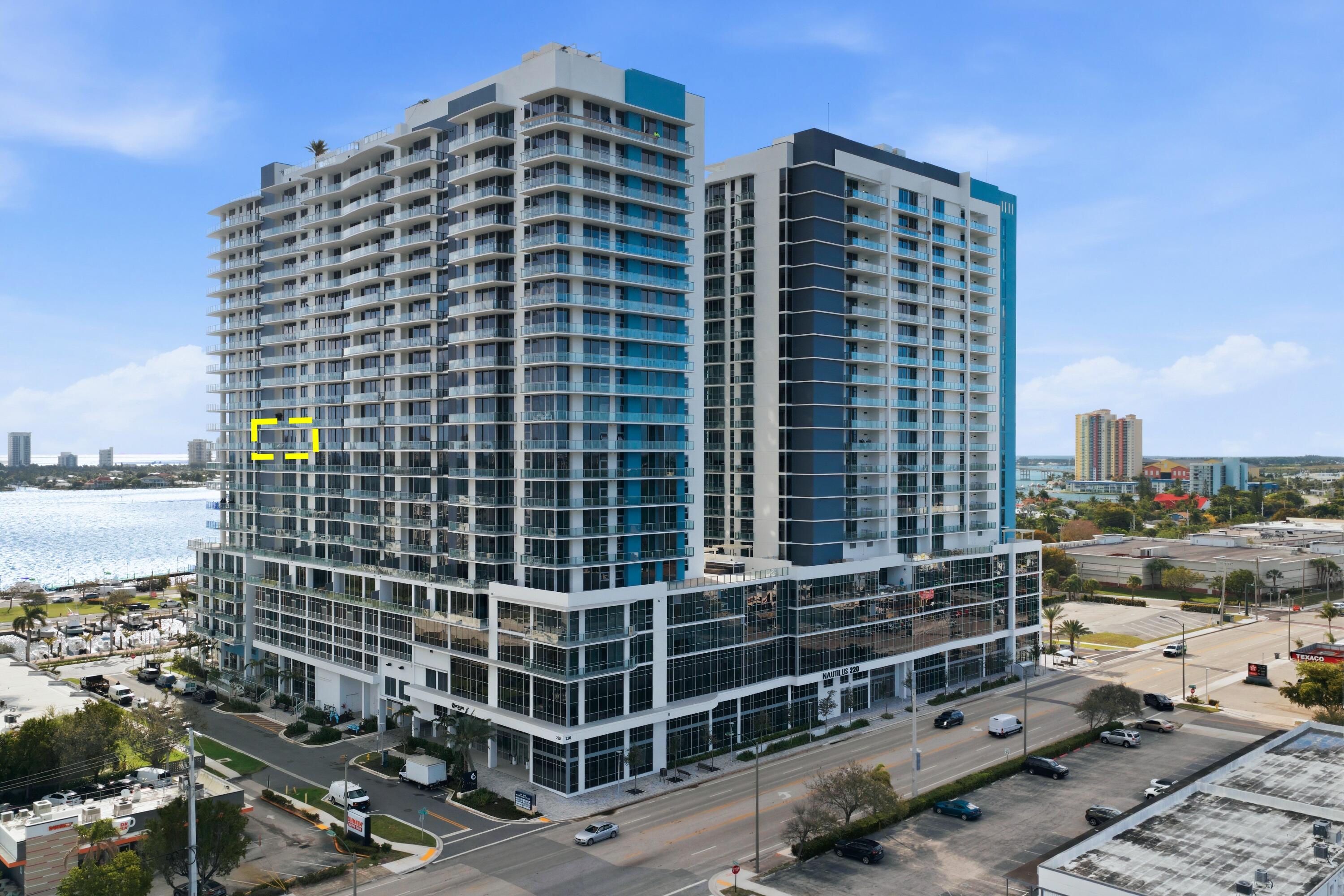 Welcome to Residence N-1205 at Nautilus 220, where refined coastal elegance meets contemporary luxury living in the heart of the Palm Beaches. Perched on the 12th floor with coveted northeast exposure, this stunning 2-bedroom, 2 1/2-bath luxury condominium offers 1,465 square feet of thoughtfully designed living space with partial intracoastal and ocean views and abundant natural light pouring through dramatic floor-to-ceiling glass. The open-concept living and dining areas flow seamlessly to a private balcony, creating the perfect setting for enjoying ocean breezes and beautiful sunrises.  A standout architectural feature of the residence is the custom-engineered Switchable Privacy Glass wall separating the primary suite from the living area. With the touch of a button, the glass transitions from crystal-clear transparency to full opacity — allowing you to wake up to expansive ocean views from the comfort of your bed, then instantly restore complete privacy. This rare design element beautifully merges technology, luxury, and intentional living.  Beyond your residence, Nautilus 220 offers an amenity experience that rivals South Florida's most exclusive resorts.  Residents enjoy direct access from the grand lobby to the waterfront promenade and private marina, featuring 100 deep-water boat slips accommodating vessels up to 100 feet, providing effortless access to the Intracoastal Waterway, world-class fishing, and boating to the Bahamas. Ownership also includes exclusive private beach club access on nearby Singer Island, offering pristine shoreline just minutes away.  The community's resort-style amenities include a spectacular beach-entry pool with cabanas and sundeck, rooftop lap pool, multi-jet spa, and sunrise Brazilian hardwood yoga deck overlooking the water. A fully equipped state-of-the-art fitness center, spin studio, yoga studio, sauna, steam rooms, and physiotherapy suite deliver a complete wellness experience.  Designed for both relaxation and entertainment, Nautilus 220 also features a bowling lounge with bar, golf and sports simulator, putting green, theater room, poker room, billiards lounge, and a soundproof music and podcast studio. A beautifully designed resident pavilion with catering kitchen creates an elegant venue for private gatherings and social events.  Dining and convenience are seamlessly integrated into the community with SeaHawk Prime by celebrity chef David Burke, bringing a premier waterfront dining experience directly to the building, alongside an on-site café for daily enjoyment.  Residents benefit from white-glove services including valet parking, concierge, package porter service, and advanced touchless building technology, creating a lifestyle of effortless comfort and sophistication.  Residence N-1205 at Nautilus 220 is more than a condominium, it is an elevated waterfront lifestyle where modern design, marina living, luxury amenities, and ocean views converge in one of the Palm Beaches' most exciting new developments.  NOTE:  Newly installed double pantry and additional closet in Primary Bedroom.  Parking space includes Electric Vehicle Charging Station.