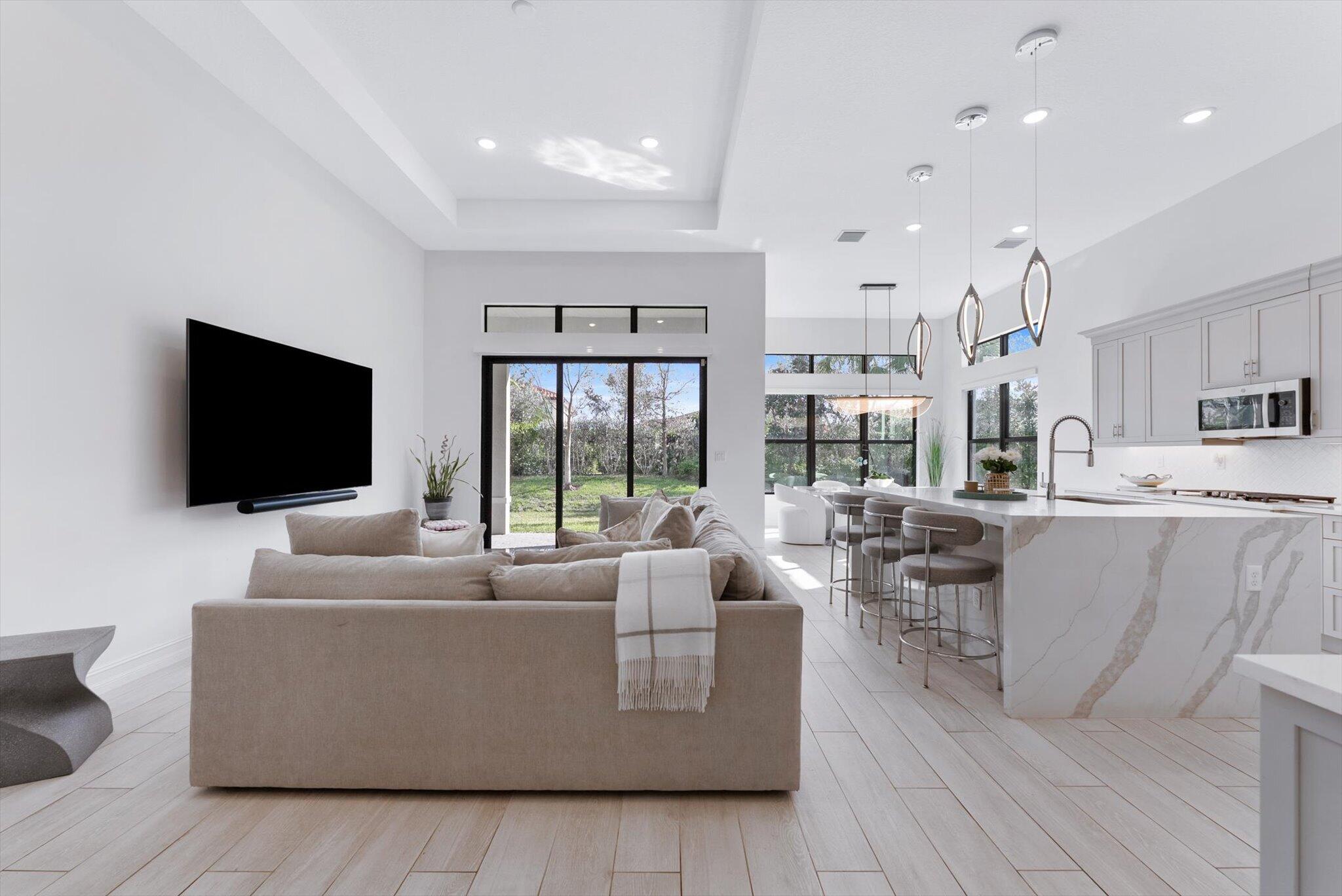 This modern home is designed for multi-generational living within a welcoming 55+ community. It features a private in-law suite with its own entrance, perfect for an elderly parent, adult child, or long-term guest, offering both independence and connection. The open-concept main living areas are ideal for entertaining, complemented by stylish finishes and porcelain tile flooring throughout.
The luxurious kitchen boasts premium appliances, double ovens, a gas cooktop with vented hood, and a stunning quartz waterfall island. The primary suite offers a spa-like bath with a soaking tub and separate walk-in shower. Enjoy the generously sized lanai for al fresco dining or relaxing afternoons, plus resort-style amenities including pickleball, tennis, swimming, and a beautiful clubhouse.