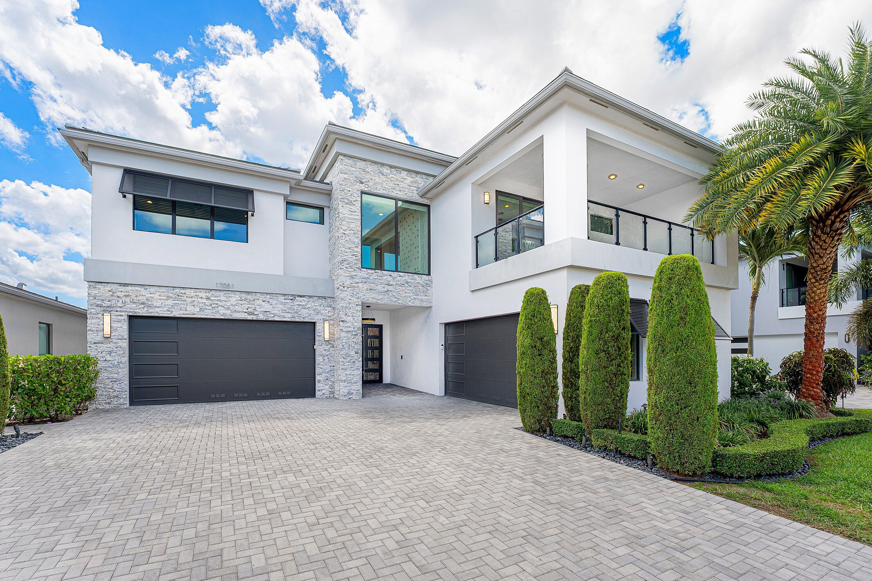 Highly sought-after MALDIVES MODEL in Lotus, situated on six-figure premium lottery lot with stunning long lake views, premium elevation, a 2-foot home extension, and over $1,000,000 in upgrades.  This meticulously maintained residence features a rare elevated backyard engineered with a retaining wall, enhancing privacy, usability and lake views. The dramatic two-story screened enclosure creates the feel of an additional outdoor living space, surrounding     the custom saltwater pool with heating and cooling system. The custom pool includes a $60,000 seamless built-in automatic pool cover -- a high-end system designed to help keep the pool protected from debris, animals, and unauthorized access, while also providing added  peace of mind for families with children. The backyard also includes an upgraded outdoor kitchen and upgraded cabana bath, creating the perfect setting for entertaining. Home offers four ensuite bedrooms plus the primary suite upstairs, with an enclosed front balcony adding seamless living space, ideal for a playroom, office or lounge. The main level includes designer kitchen with oversized island, full quartz backsplash, custom wine room with built-in wine fridge, hardwood floors throughout, and glass railing staircase adding a clean, modern open feel. Additional highlights: Full Swing sports simulator with 16 sports and games, extended driveway, full home generator, Bahama shutters, extended  4-car garage with extra long bays for oversized vehicle, 3 main A/C units, plus dedicated A/C units, for garage and simulator room. Garage can be  configured with a lift to accommodate 5 vehicles. (Lift is not included in the purchase) *A truly rare Lotus offering with luxury upgrades, incredible views, and exceptional functionality.